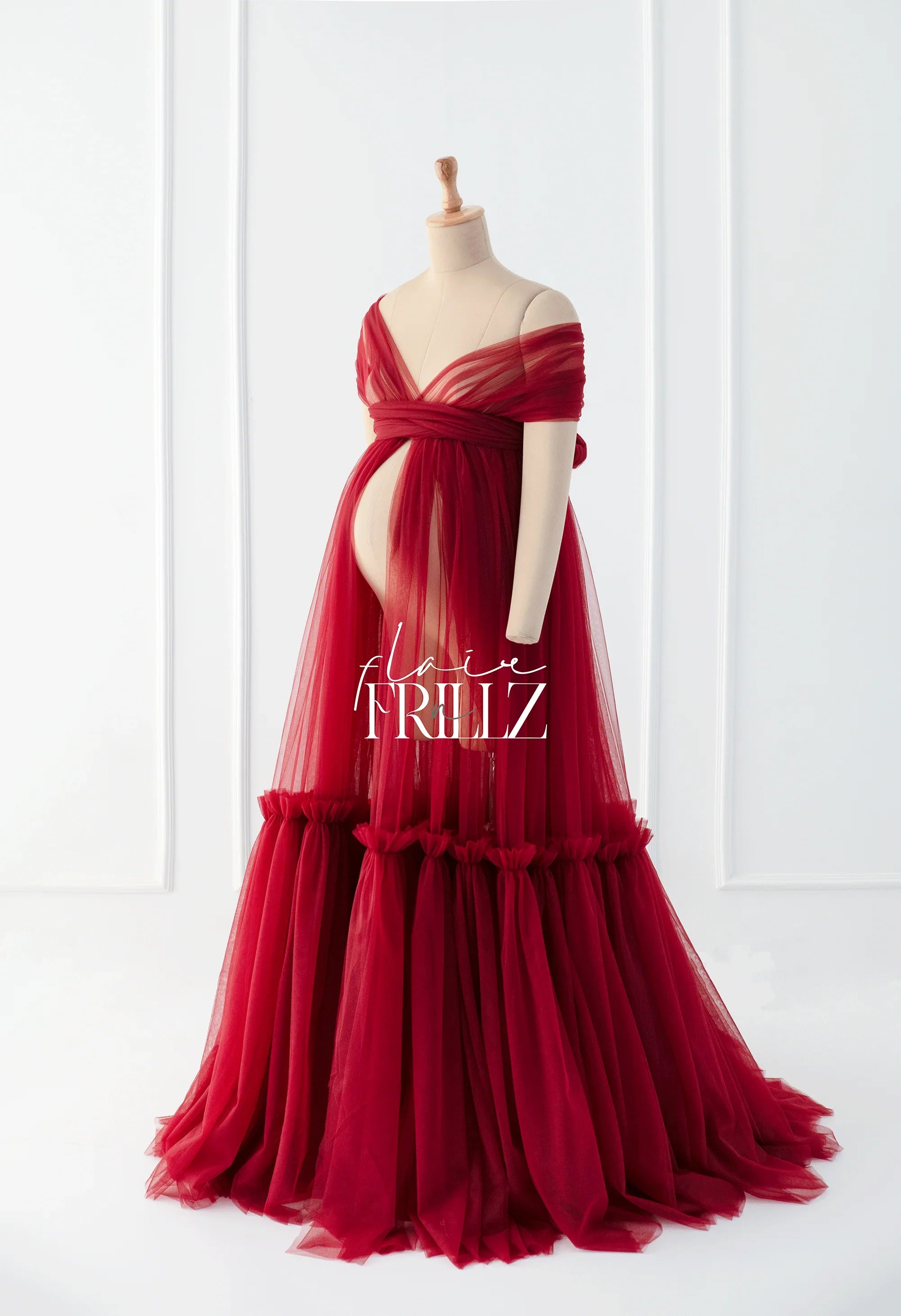 Red off-shoulder maternity gown with tulle skirt on mannequin, elegant pregnancy dress