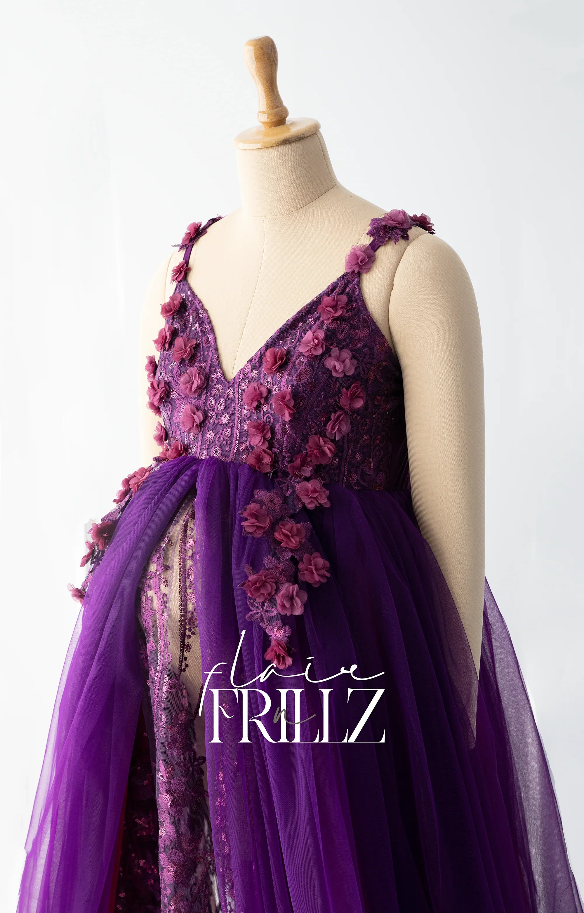 Purple floral maternity gown with lace details and 3D flowers on a mannequin