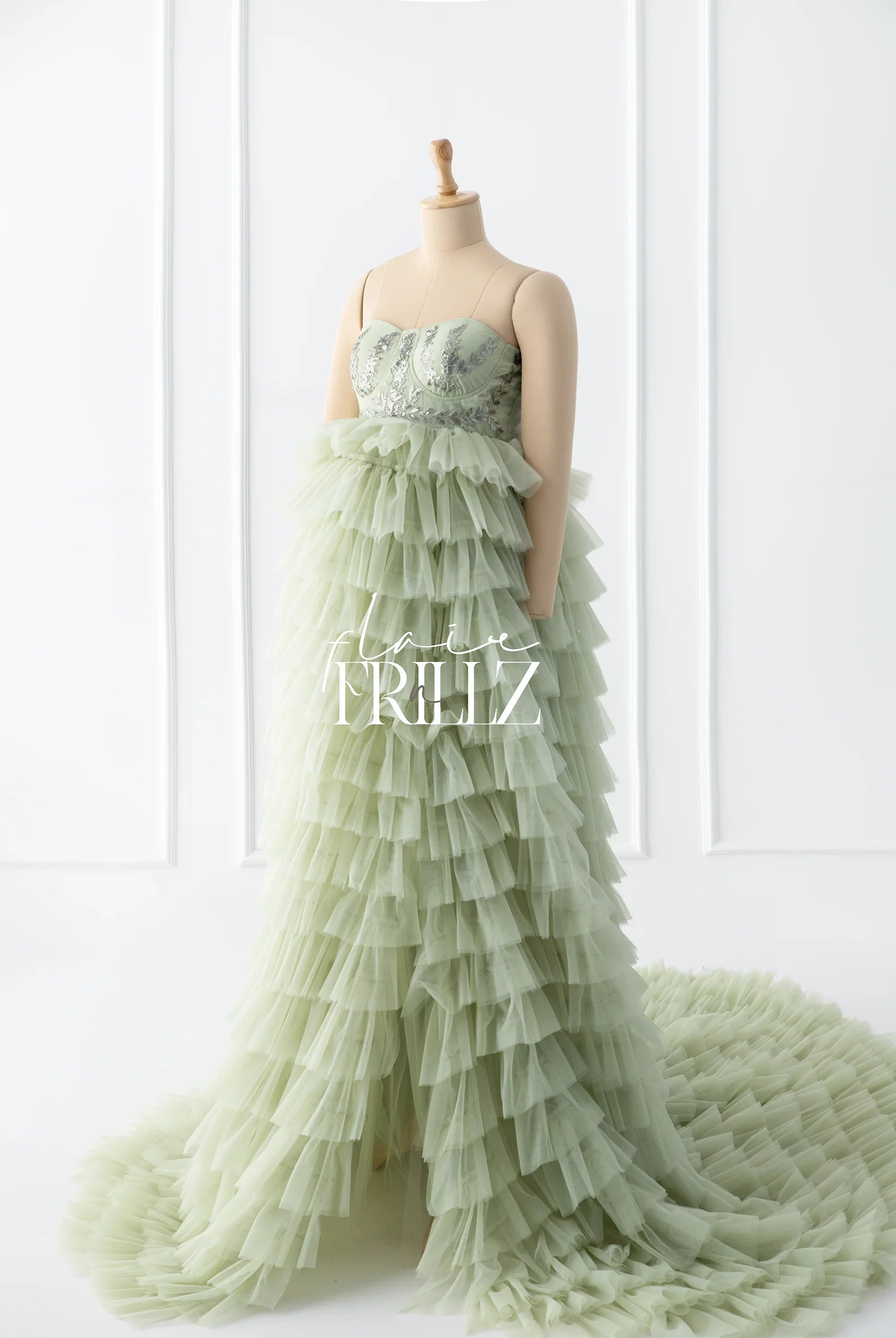Light green ruffled maternity gown with embellished bodice displayed on mannequin