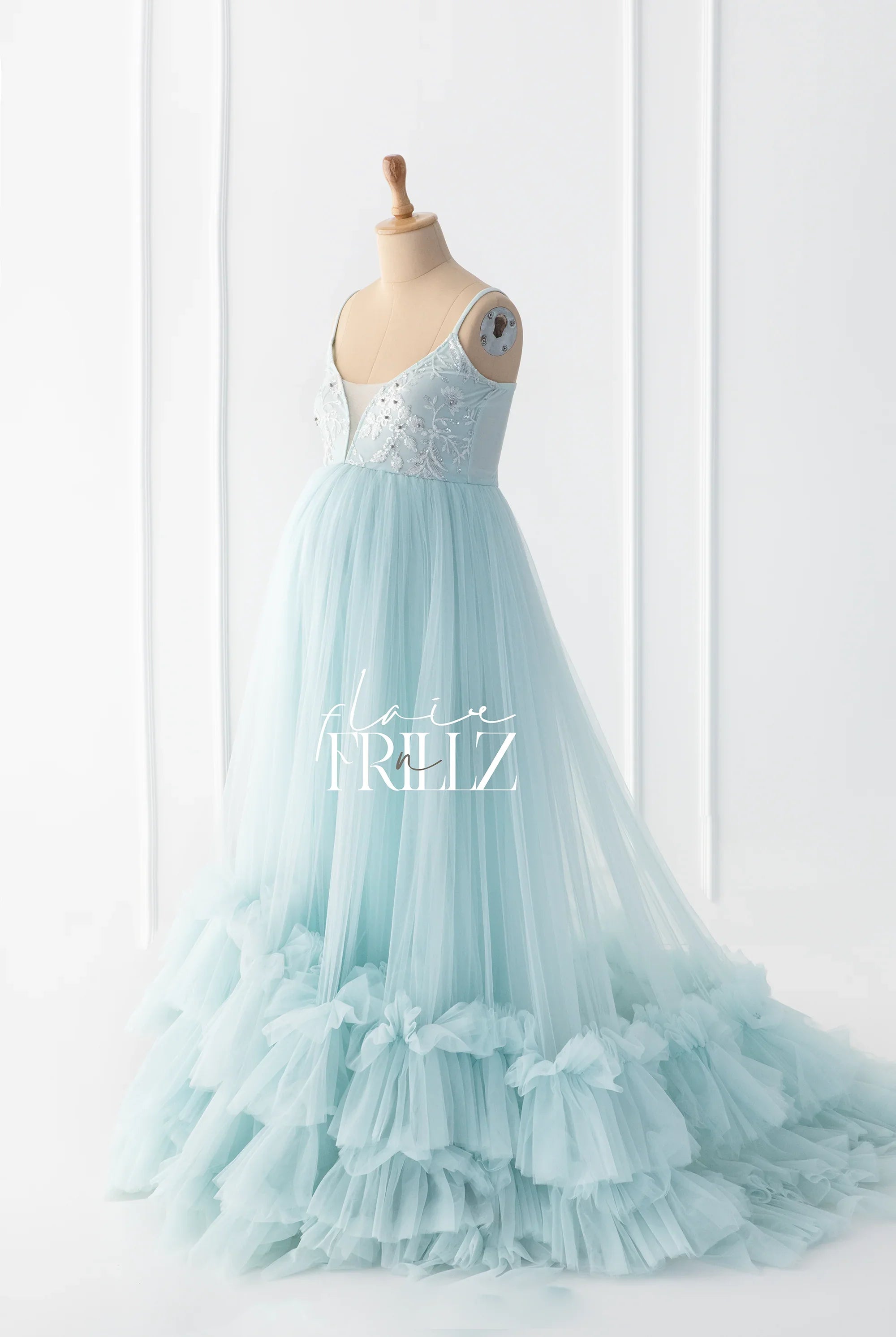 Light blue maternity gown with ruffled tulle skirt and sequin bodice on a mannequin