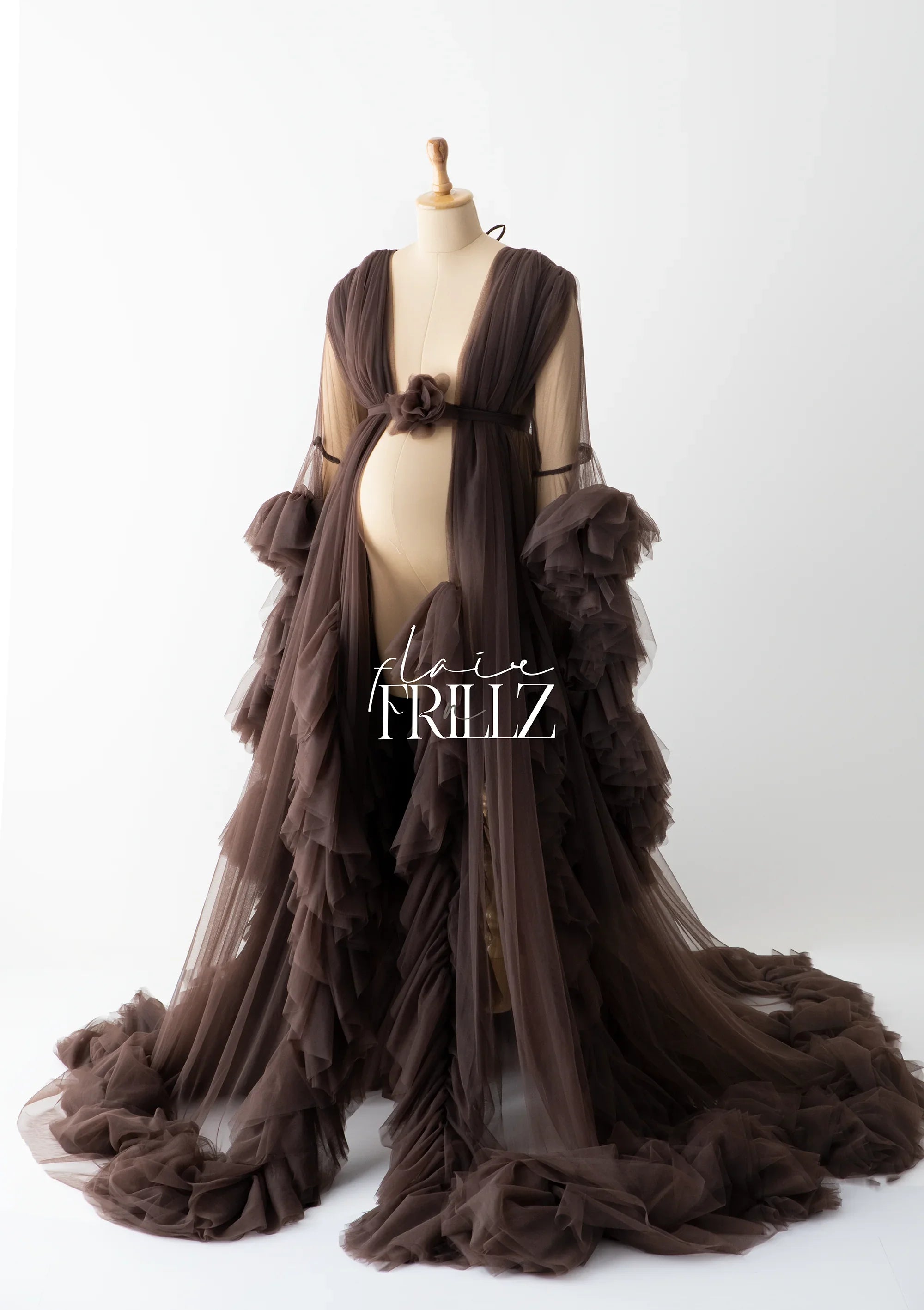 Brown ruffled maternity gown with sheer tulle and long train on mannequin