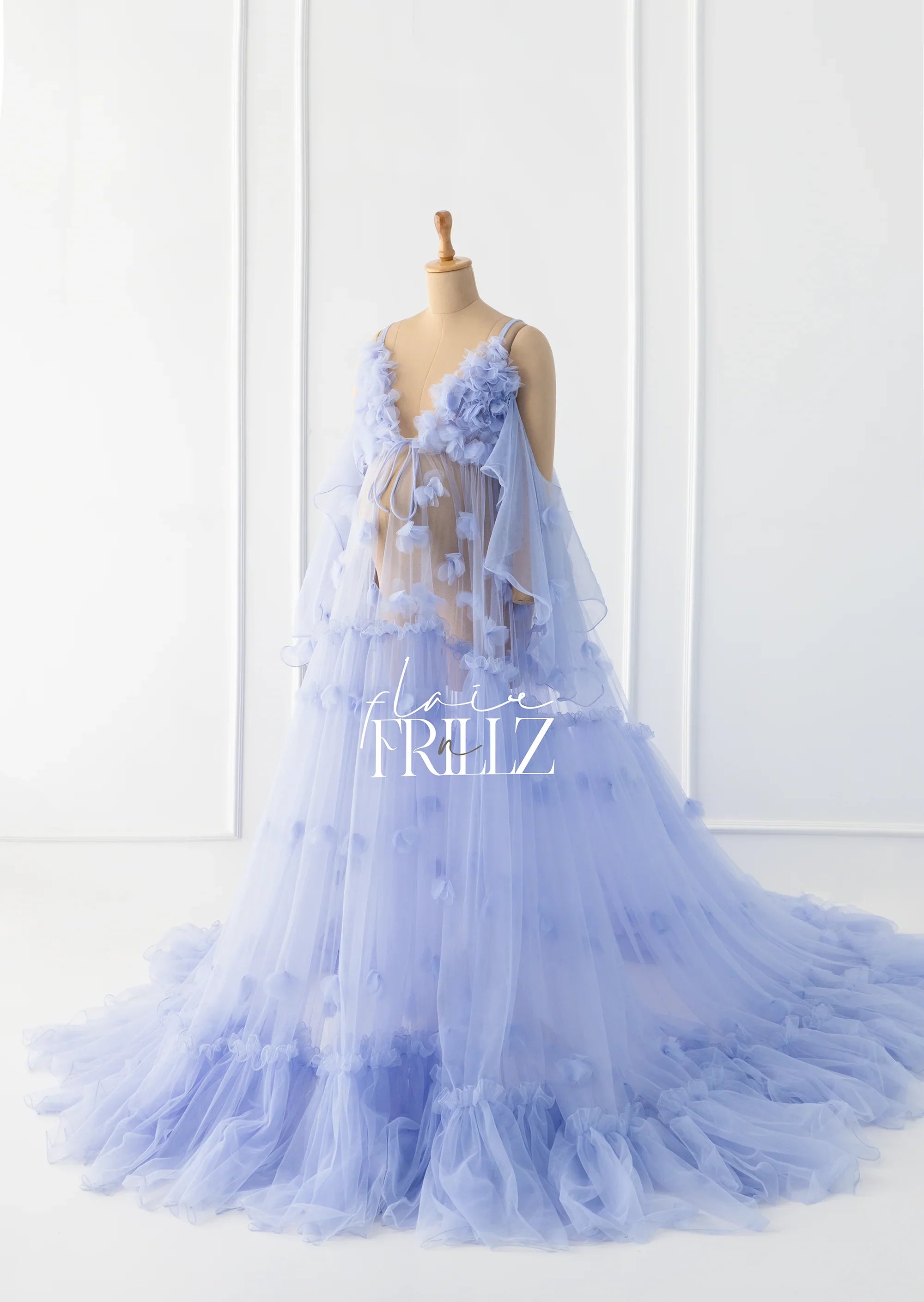Sheer lilac maternity gown with floral appliqué and flowing tulle skirt on mannequin