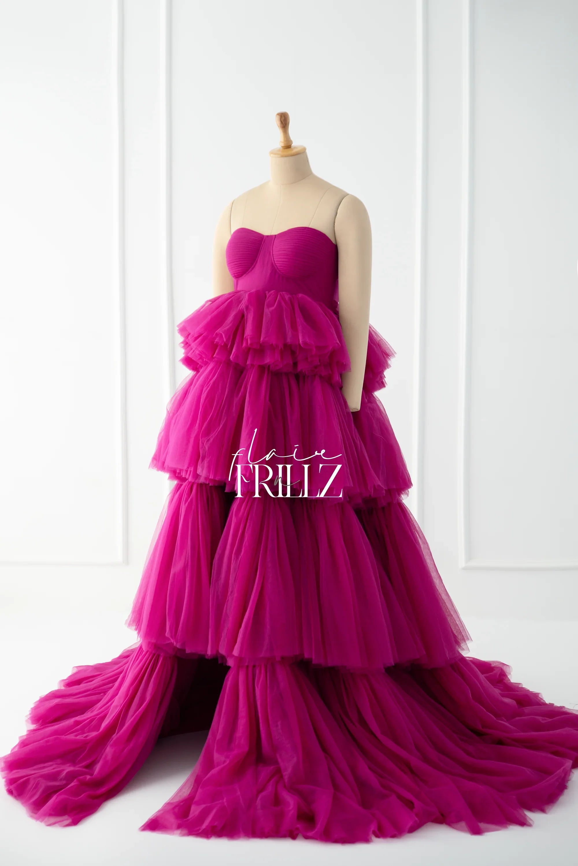 Vibrant magenta strapless maternity gown with tiered tulle layers on a mannequin