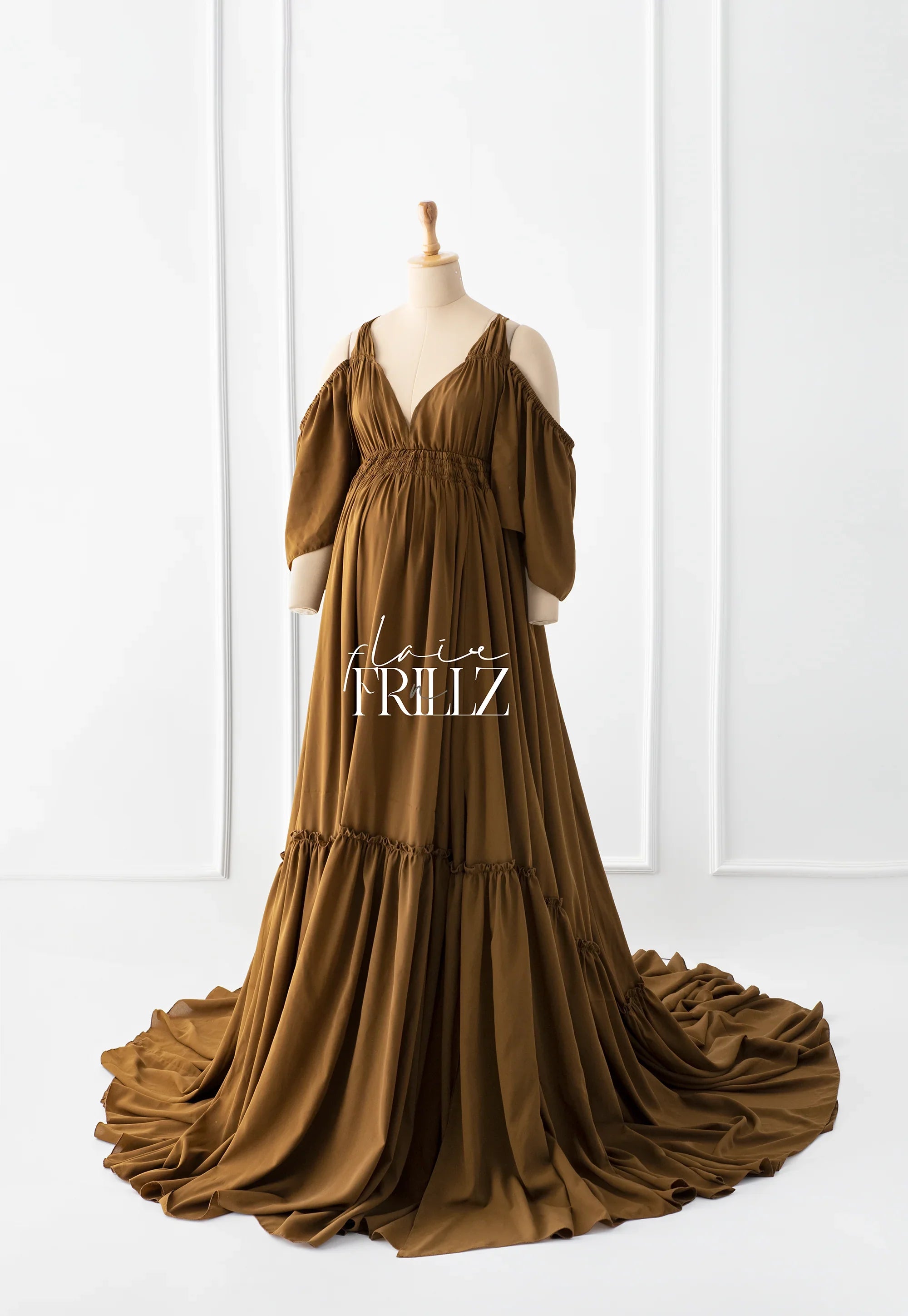 Boho brown maternity gown with off-shoulder sleeves and flowing train on mannequin