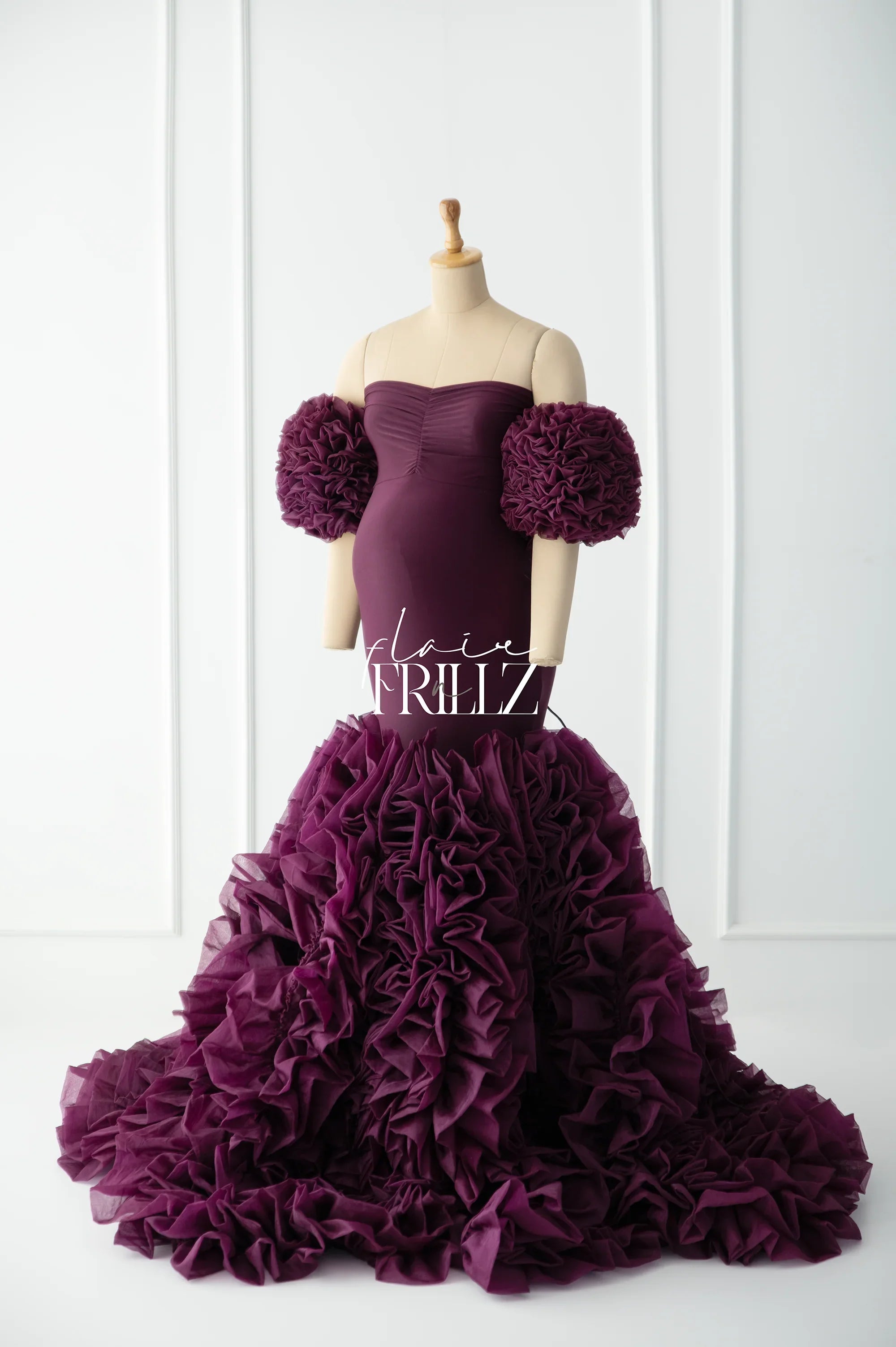 Burgundy fishtail maternity gown with dramatic ruffled sleeves and layered tulle skirt on mannequin