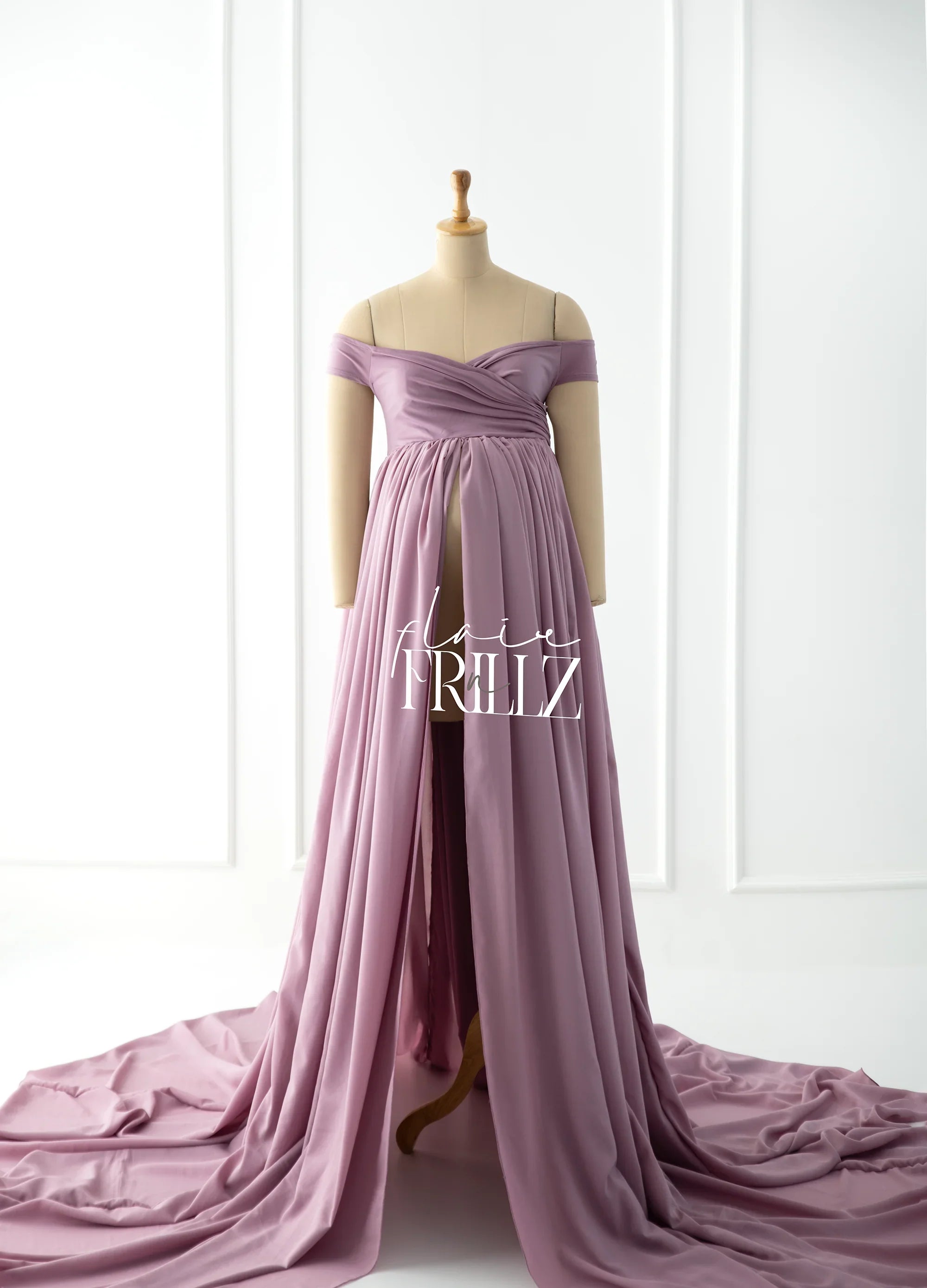 Lavender off-shoulder maternity gown with flowing skirt on mannequin in bright studio
