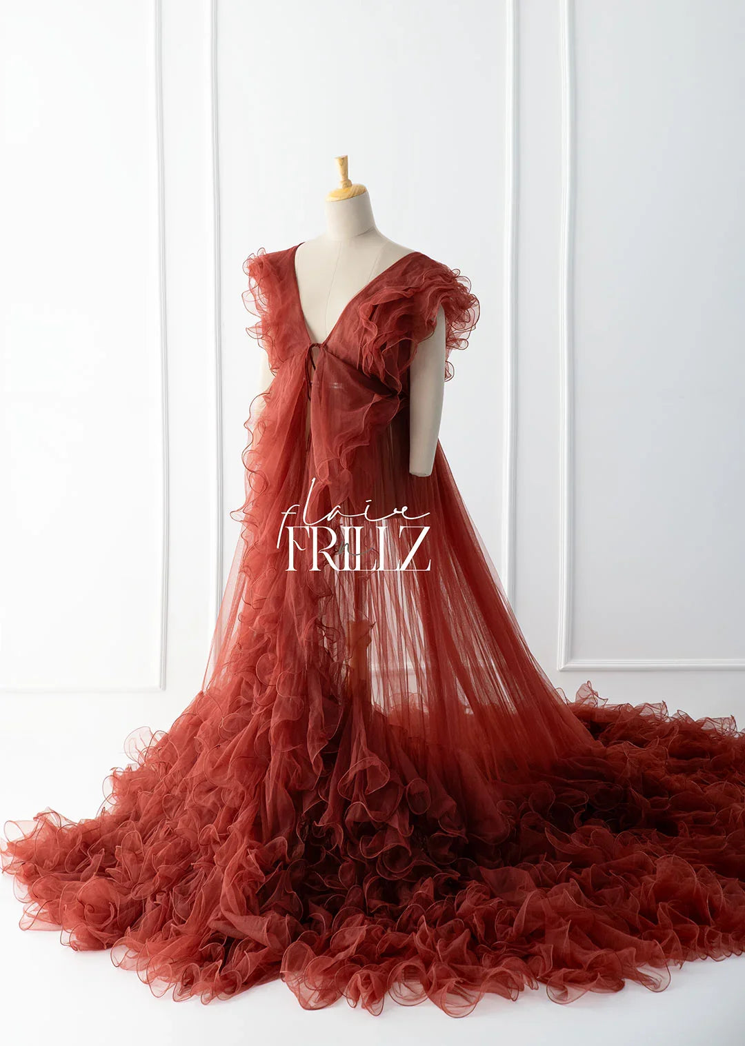 Elegant rust-colored maternity gown with ruffled layers and flowing train for stylish pregnancy wear