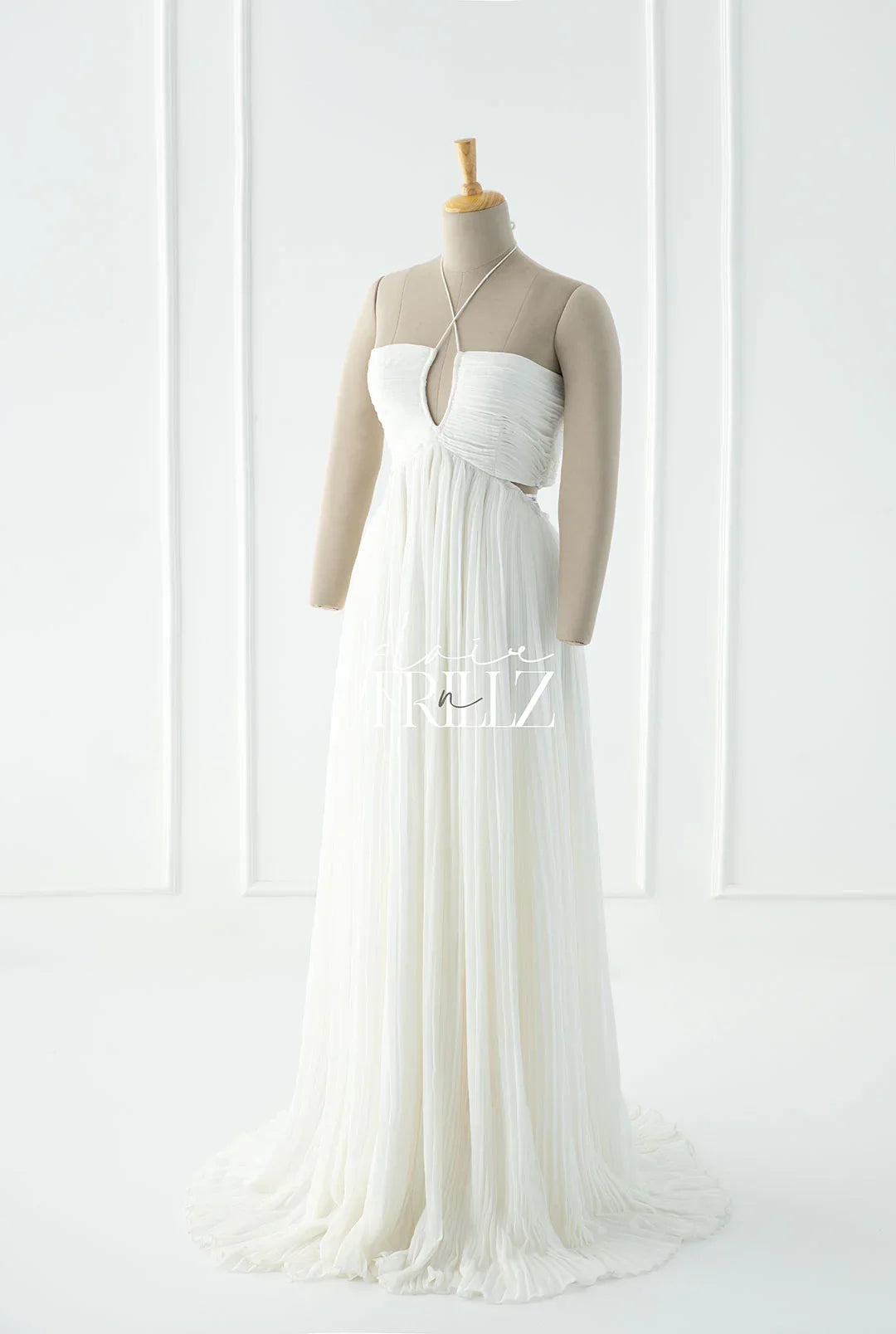 Elegant white maternity gown with keyhole neckline and pleated skirt on mannequin