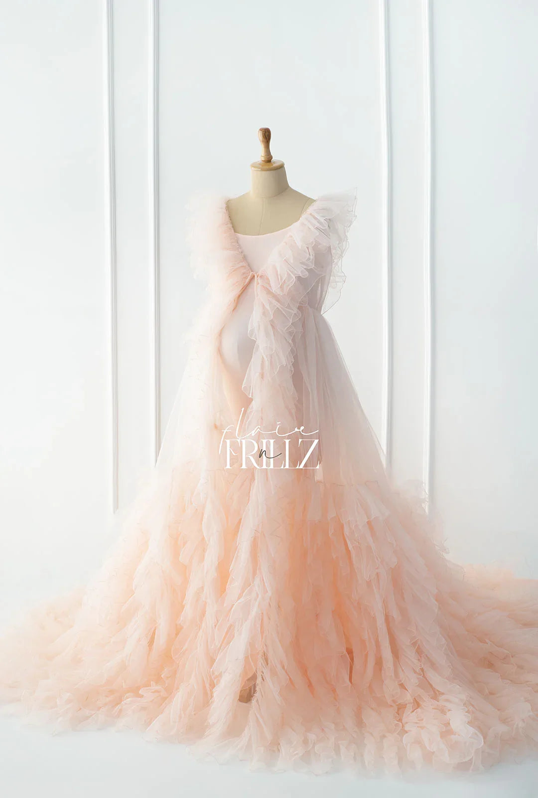 Elegant peach maternity gown with ruffled layers, perfect for pregnancy photoshoots and special occasions.