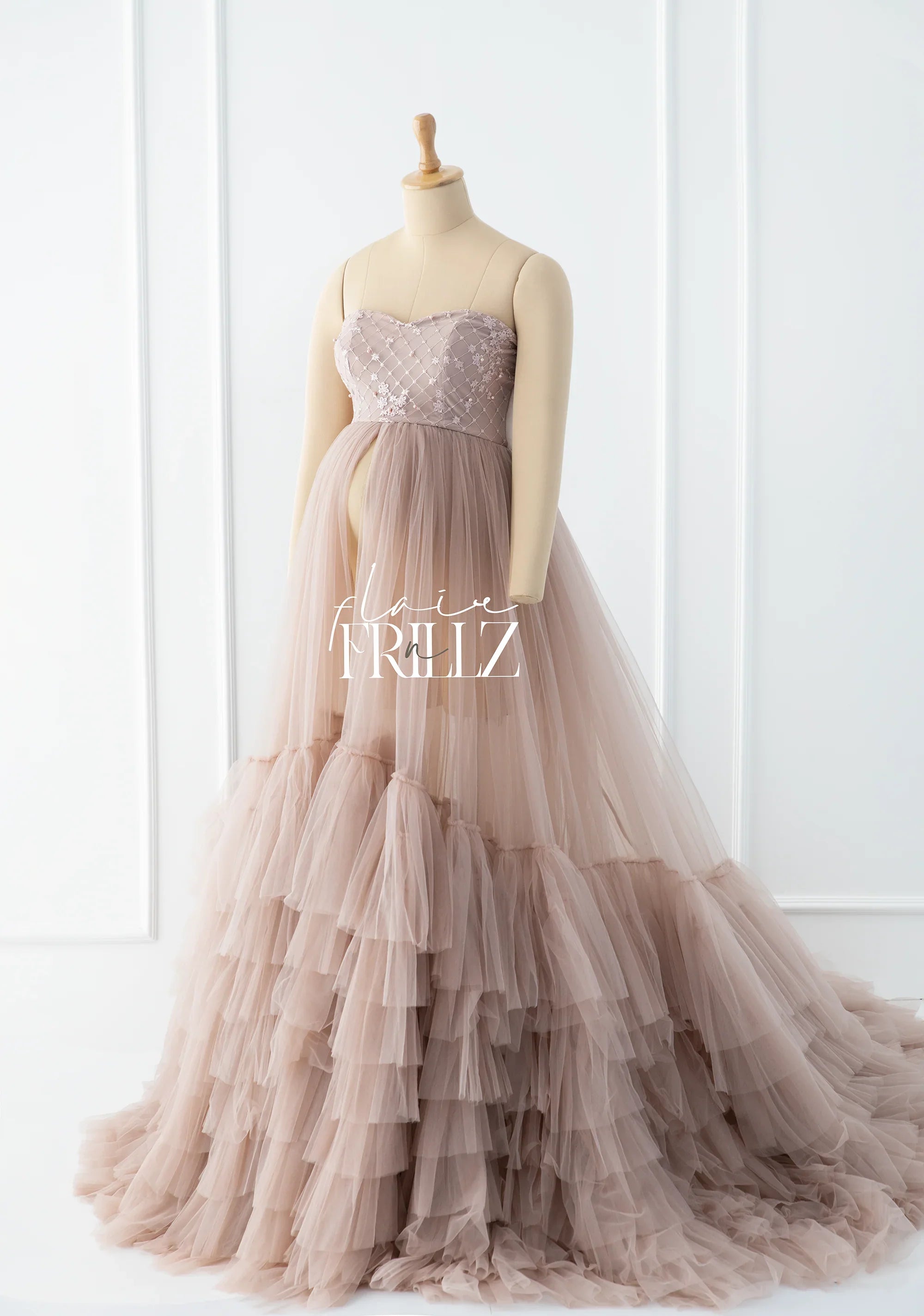 Blush pink maternity gown with layered tulle skirt and strapless embroidered bodice on mannequin