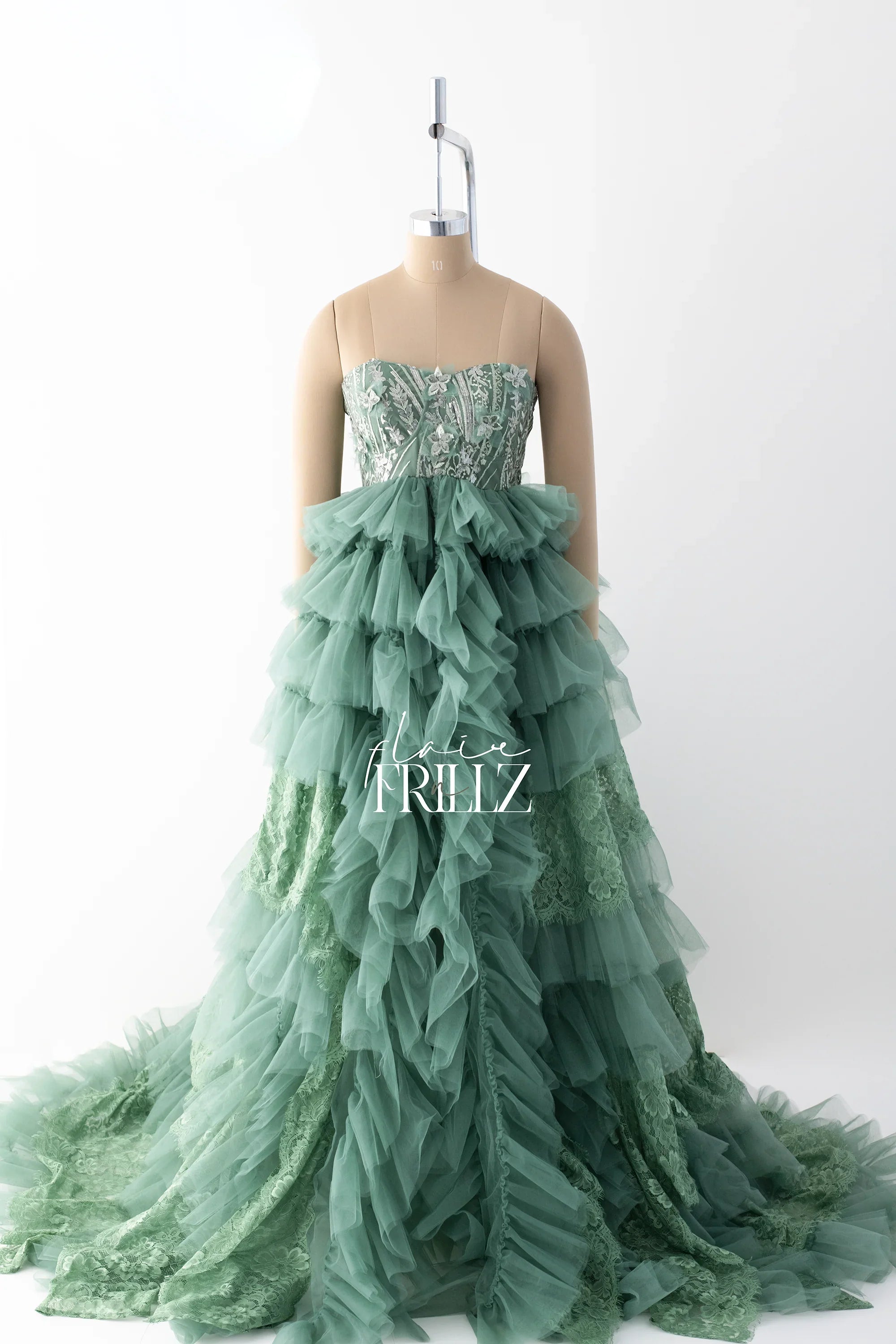 Green maternity gown with floral lace bodice and tiered tulle ruffle skirt on mannequin