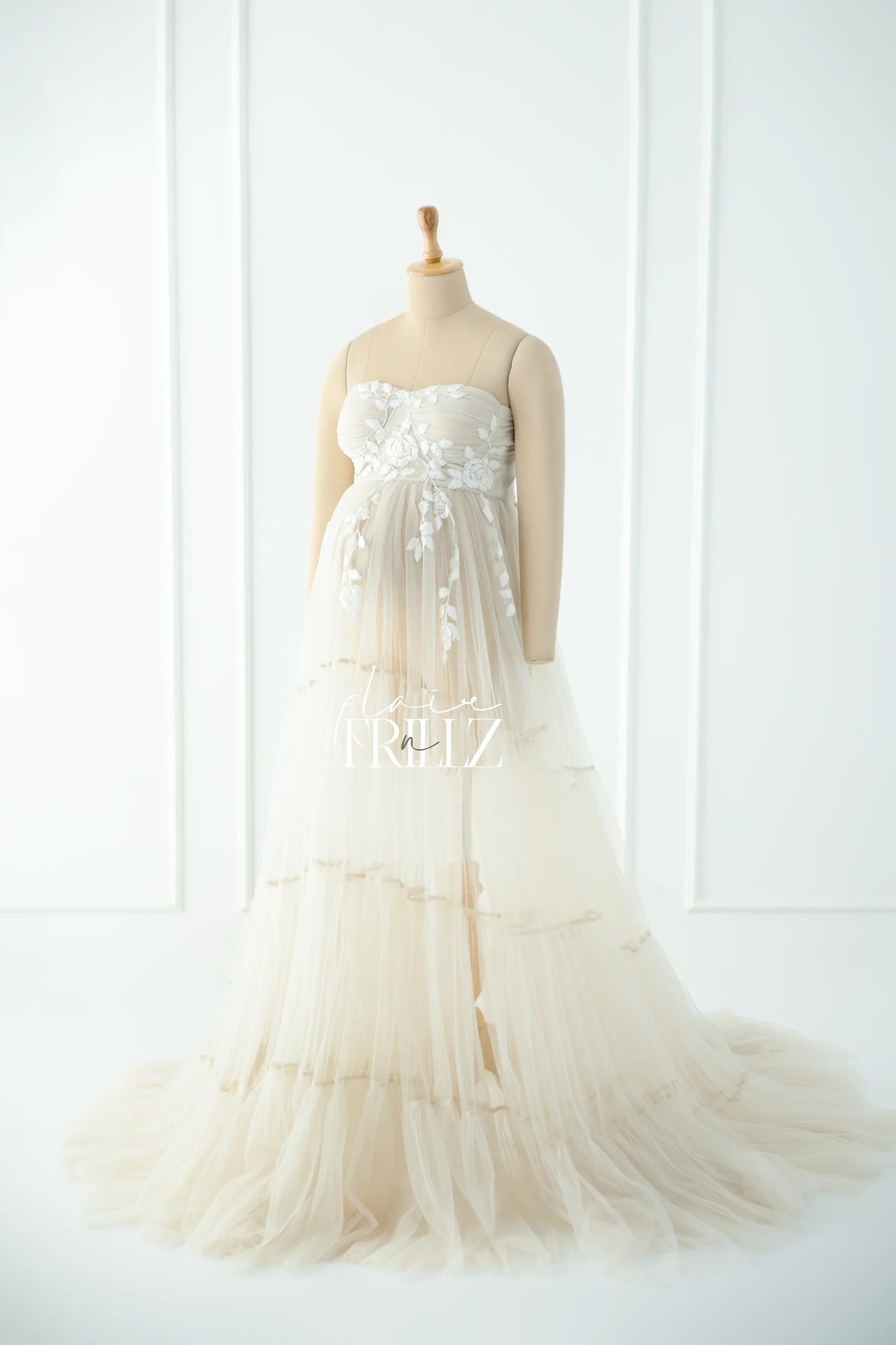 Ivory strapless maternity gown with floral embroidery and layered tulle skirt on mannequin