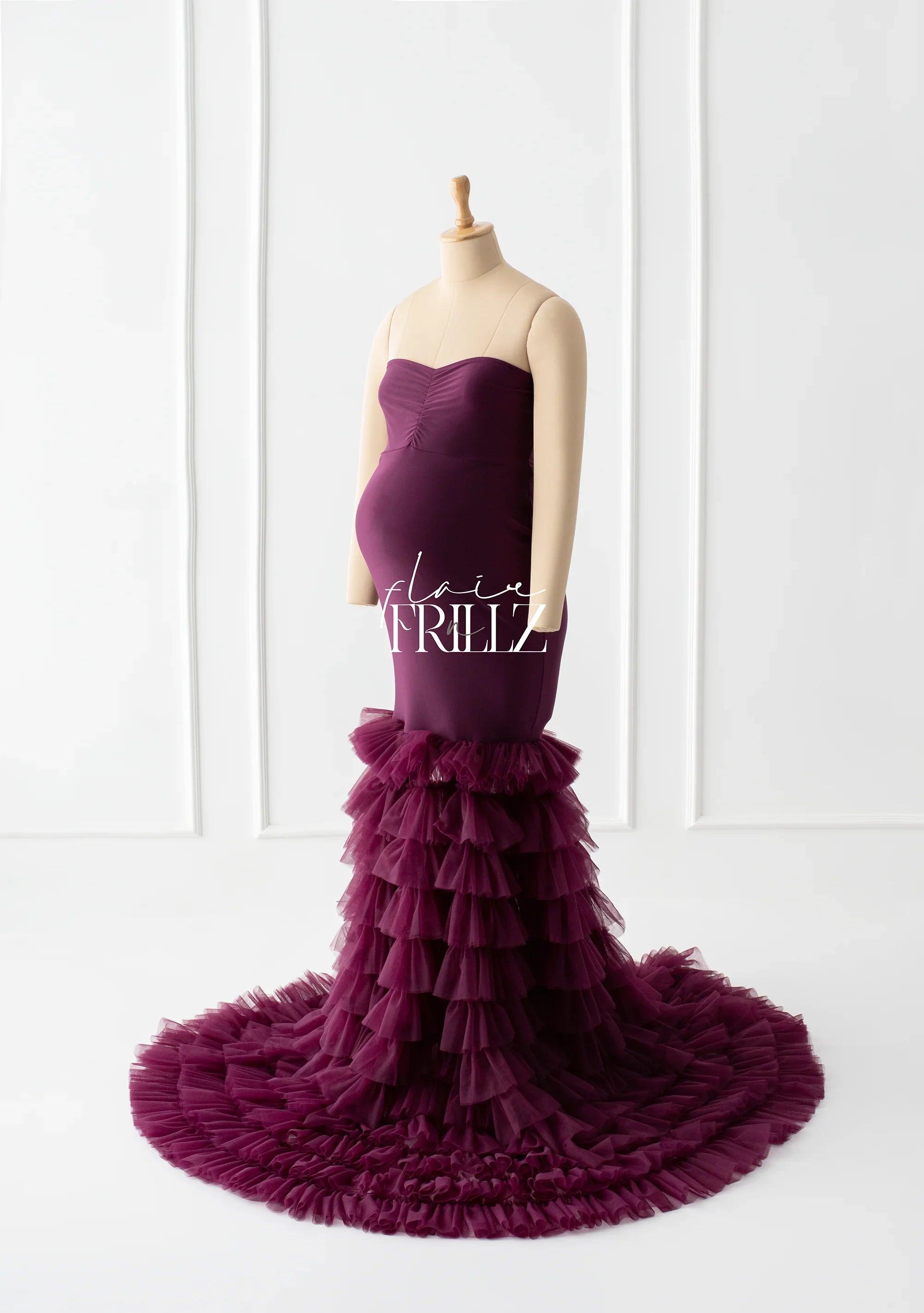 Burgundy strapless maternity gown with ruffled tulle mermaid skirt on mannequin