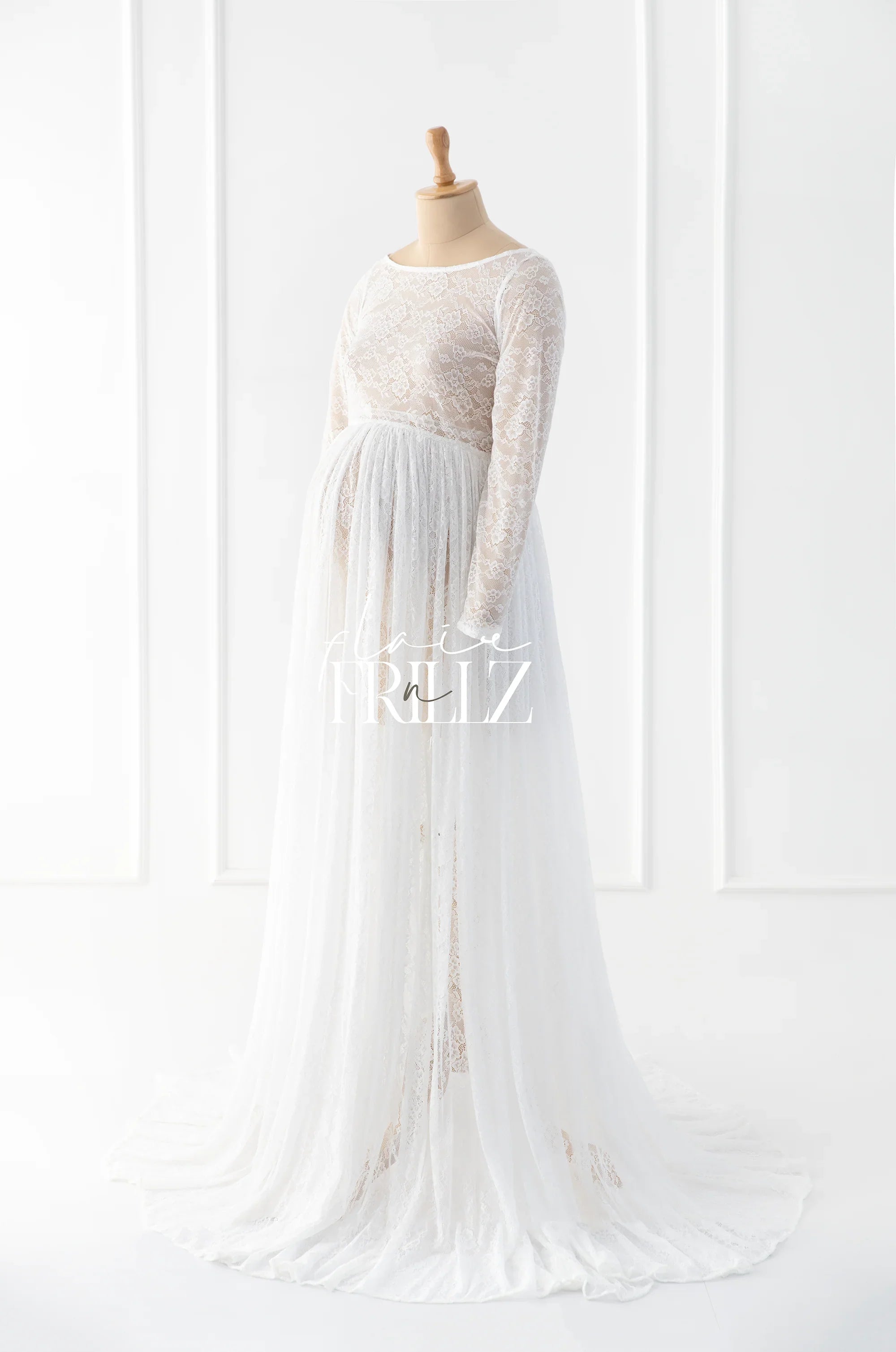 White lace boho maternity gown with long sleeves and flowing skirt on mannequin
