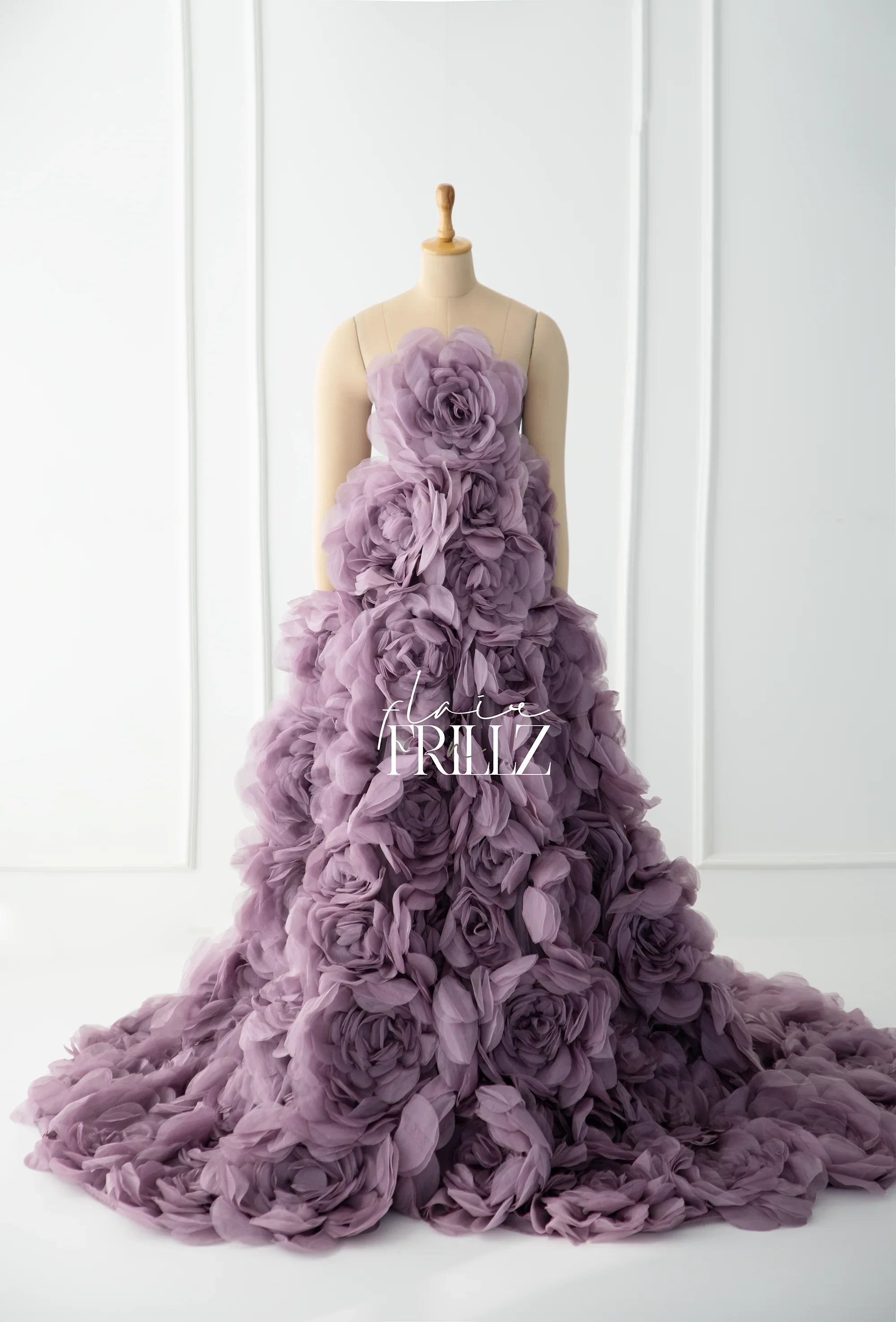 Mauve maternity gown with large textured floral appliqués, displayed on a mannequin.