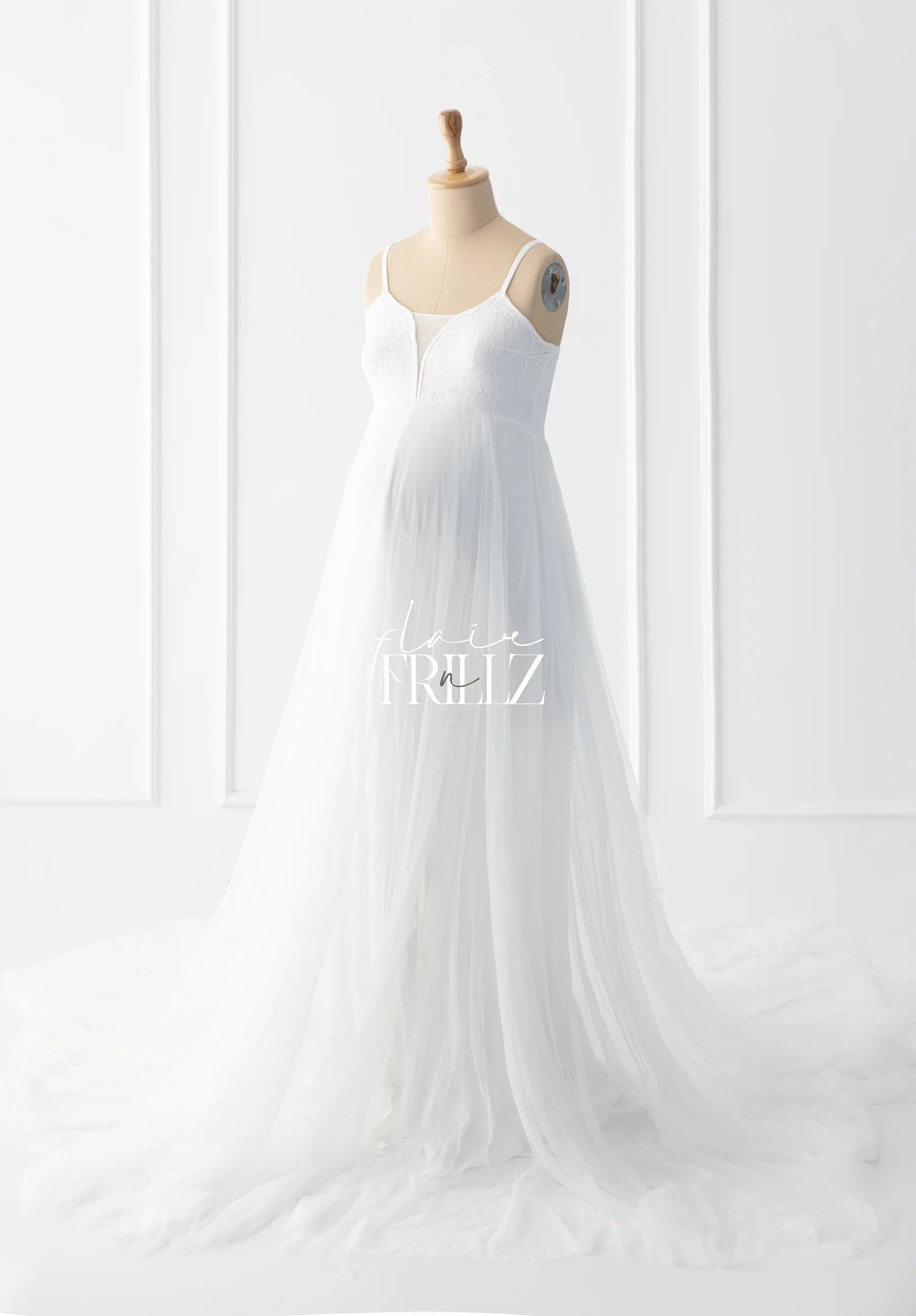 White boho maternity gown with lace bodice and flowing tulle skirt on mannequin