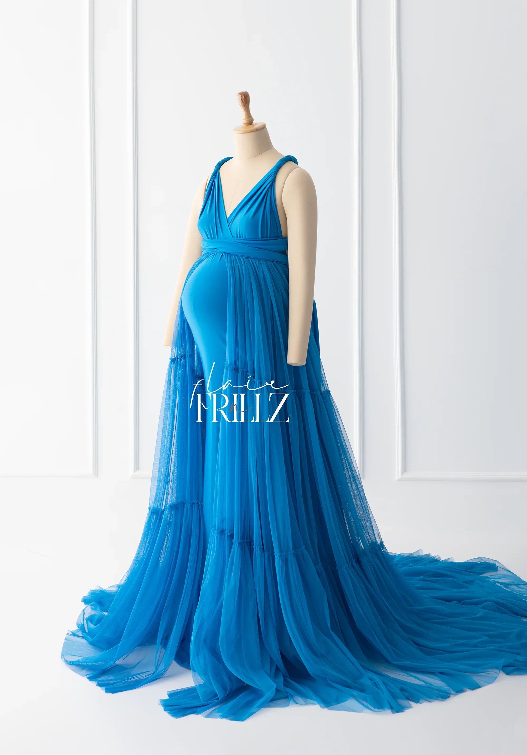 Elegant bright blue maternity gown with flowing tulle skirt on mannequin in white studio
