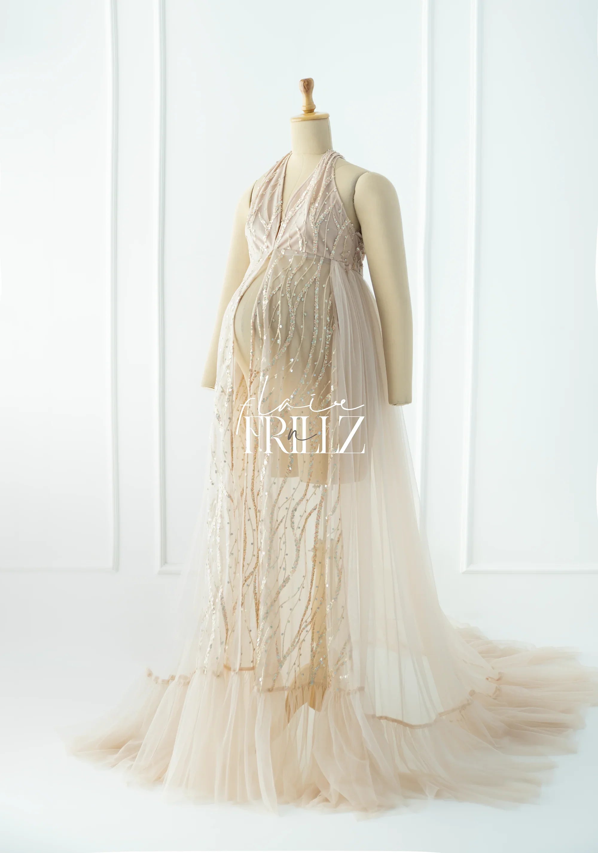 Elegant beige maternity gown with sequin details and tulle skirt on mannequin