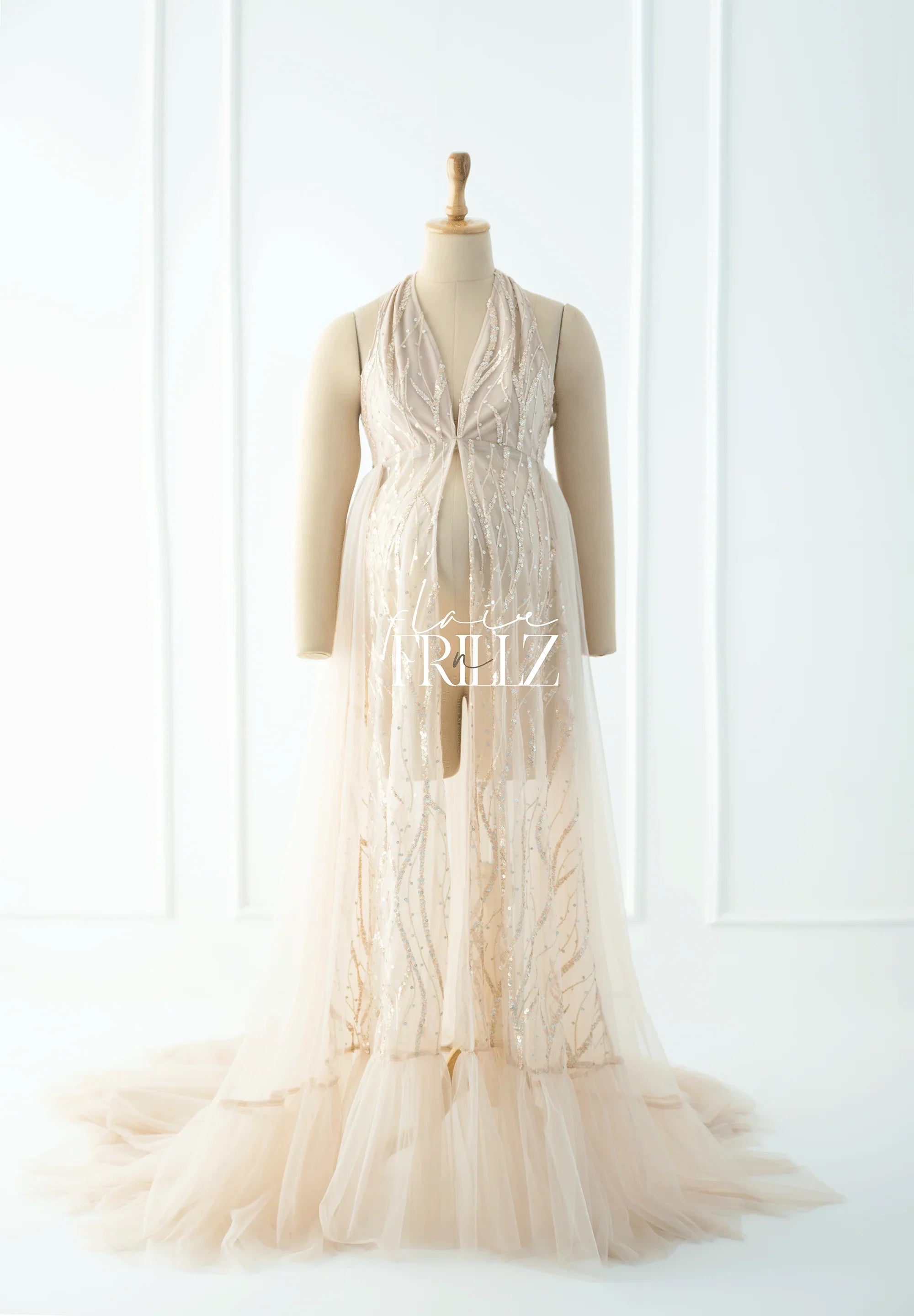 Elegant beige maternity gown with sequin detailing and tulle train on mannequin