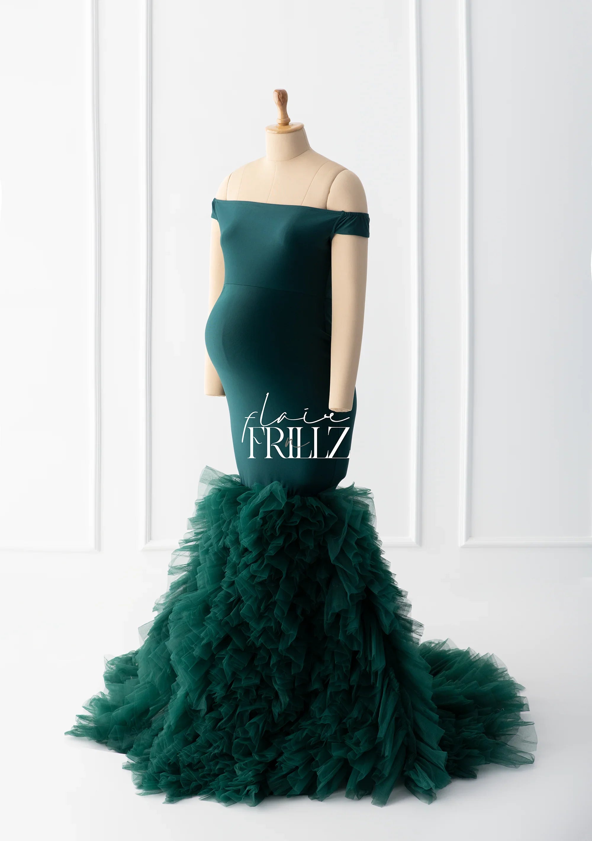 Emerald green off-shoulder maternity gown with ruffled tulle mermaid skirt on mannequin