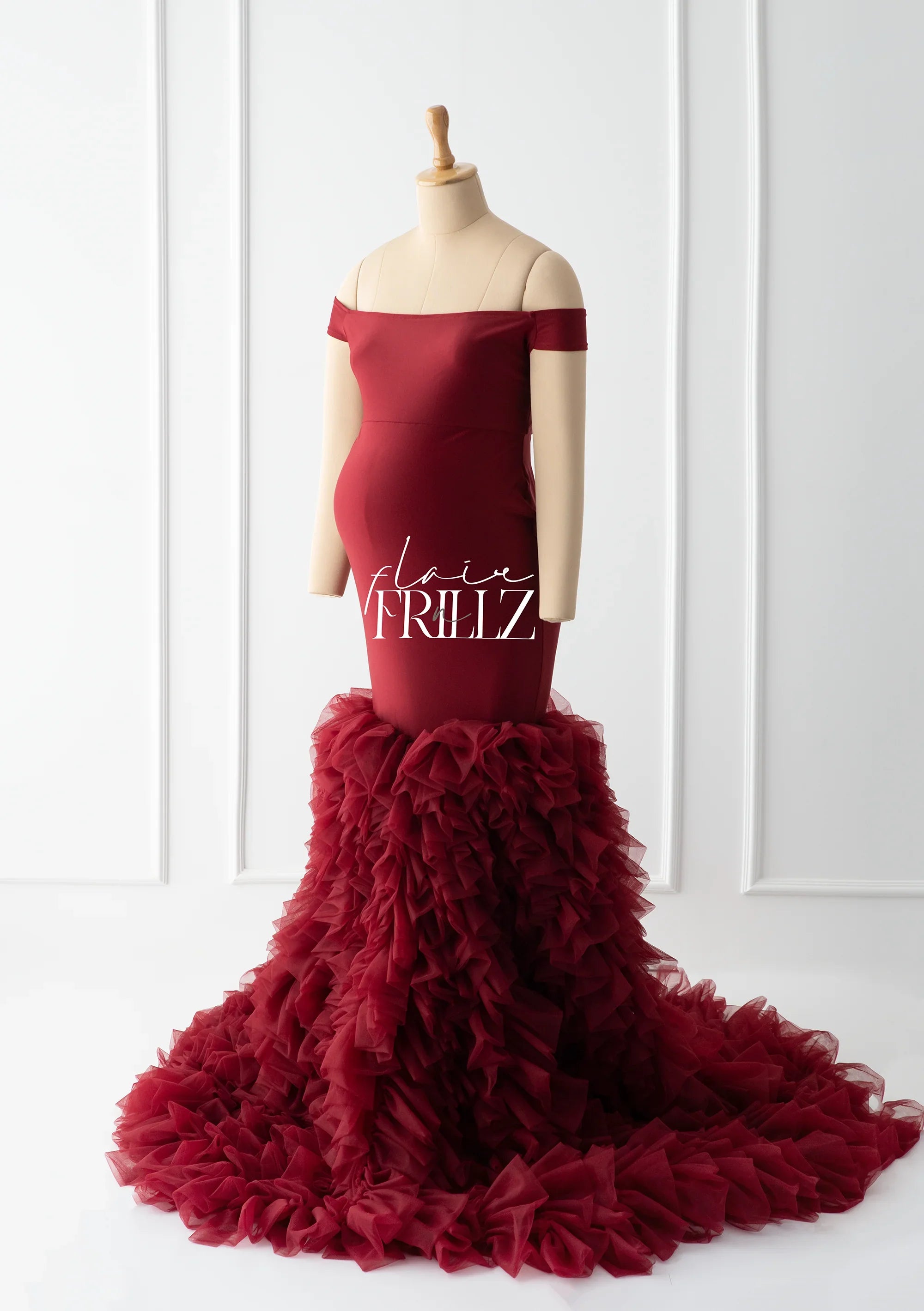 Burgundy off-shoulder maternity gown with ruffled tulle skirt on mannequin, studio setting