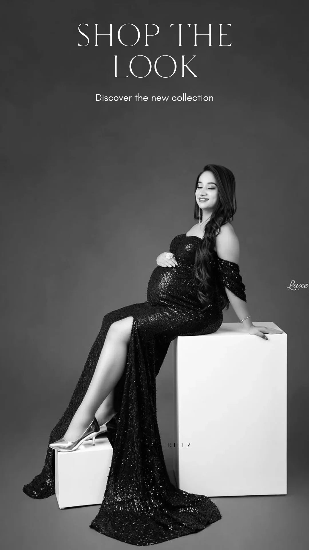 Pregnant woman in a black sequin maternity gown with off-shoulder sleeves and silver heels.
