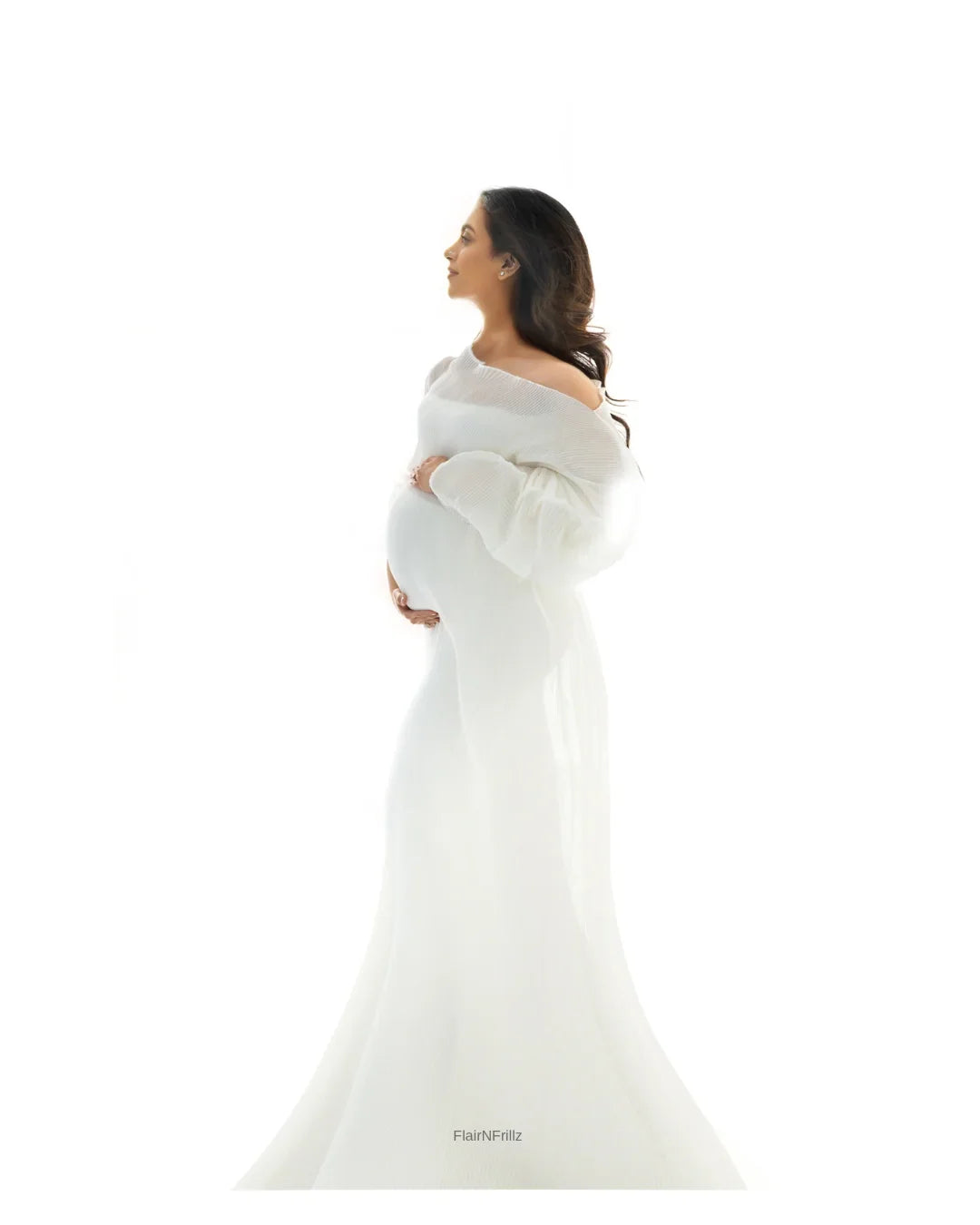 Pregnant woman in elegant white maternity gown posing against a white background