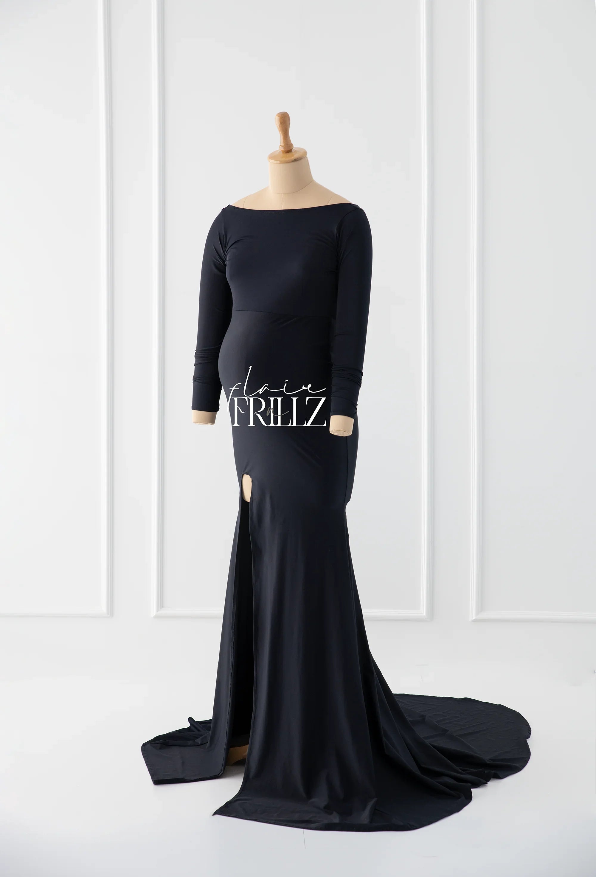 Elegant black maternity gown with long sleeves and front slit on mannequin