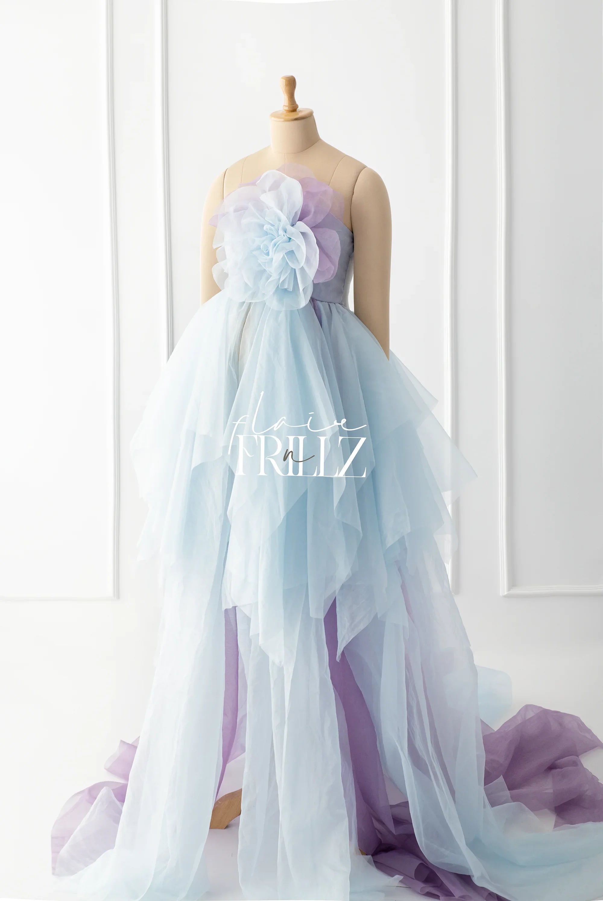 Light blue and lavender layered maternity gown with large tulle flower detail on mannequin