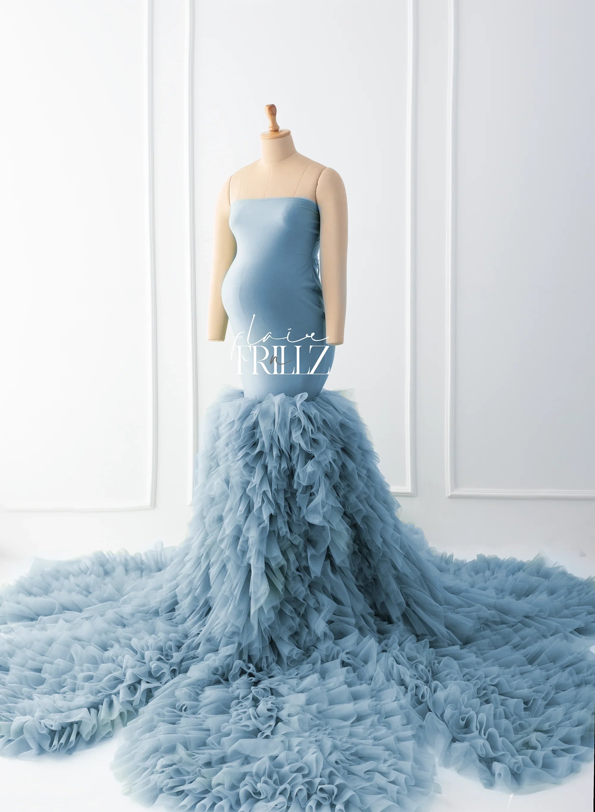 Light blue maternity gown with strapless top and dramatic ruffled tulle skirt on mannequin