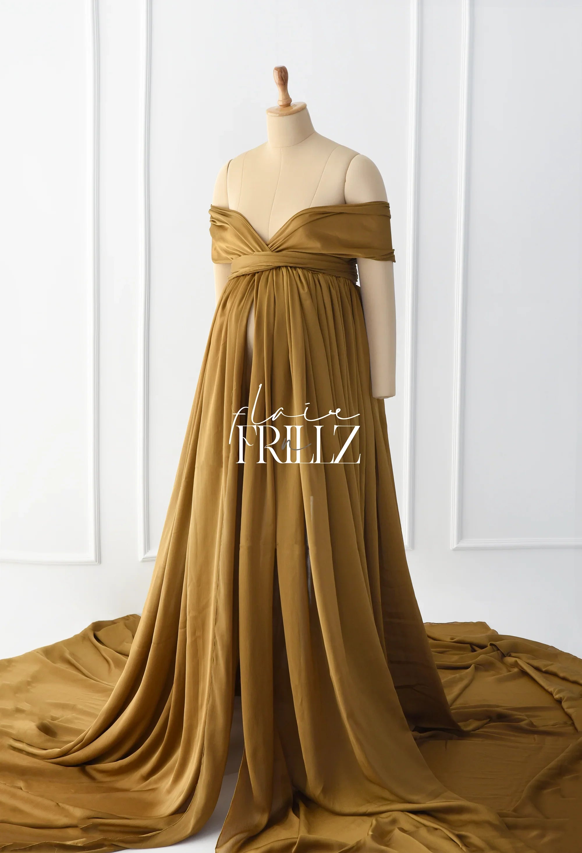Gold silky off-shoulder maternity gown with flowing train on mannequin