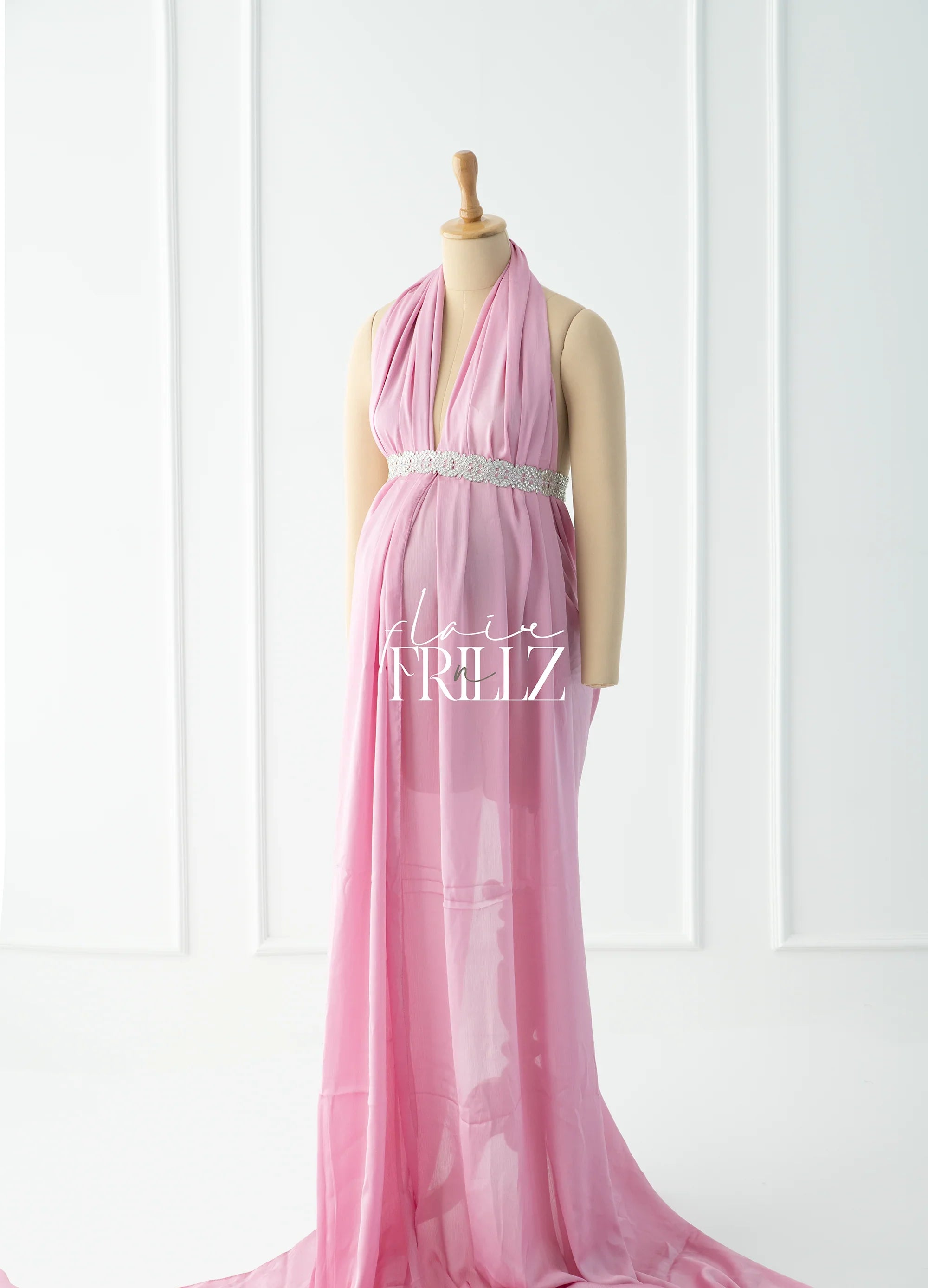Pink sheer maternity gown with halter neckline and jeweled waist, displayed on mannequin