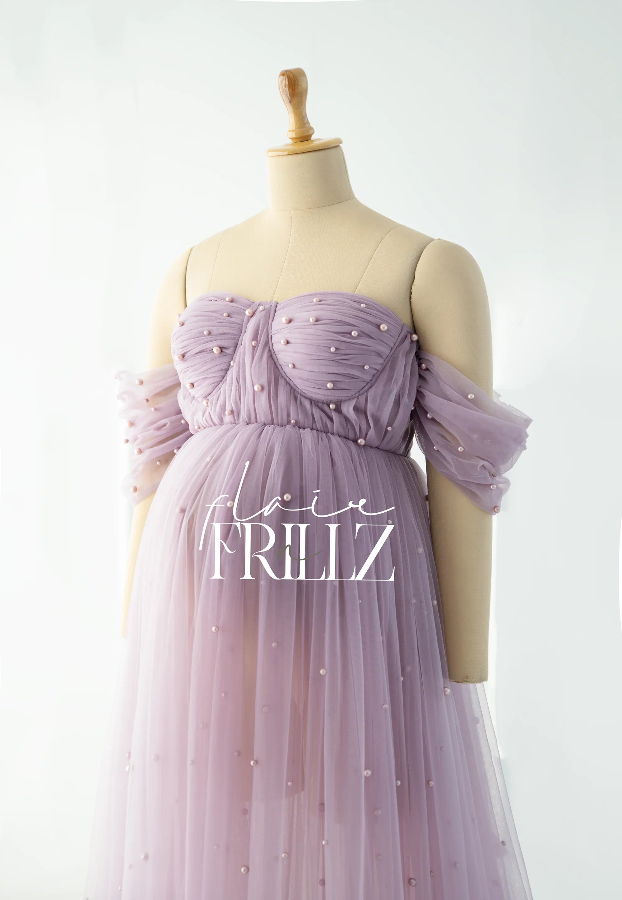 Lilac off-shoulder maternity gown with pearl accents on a mannequin