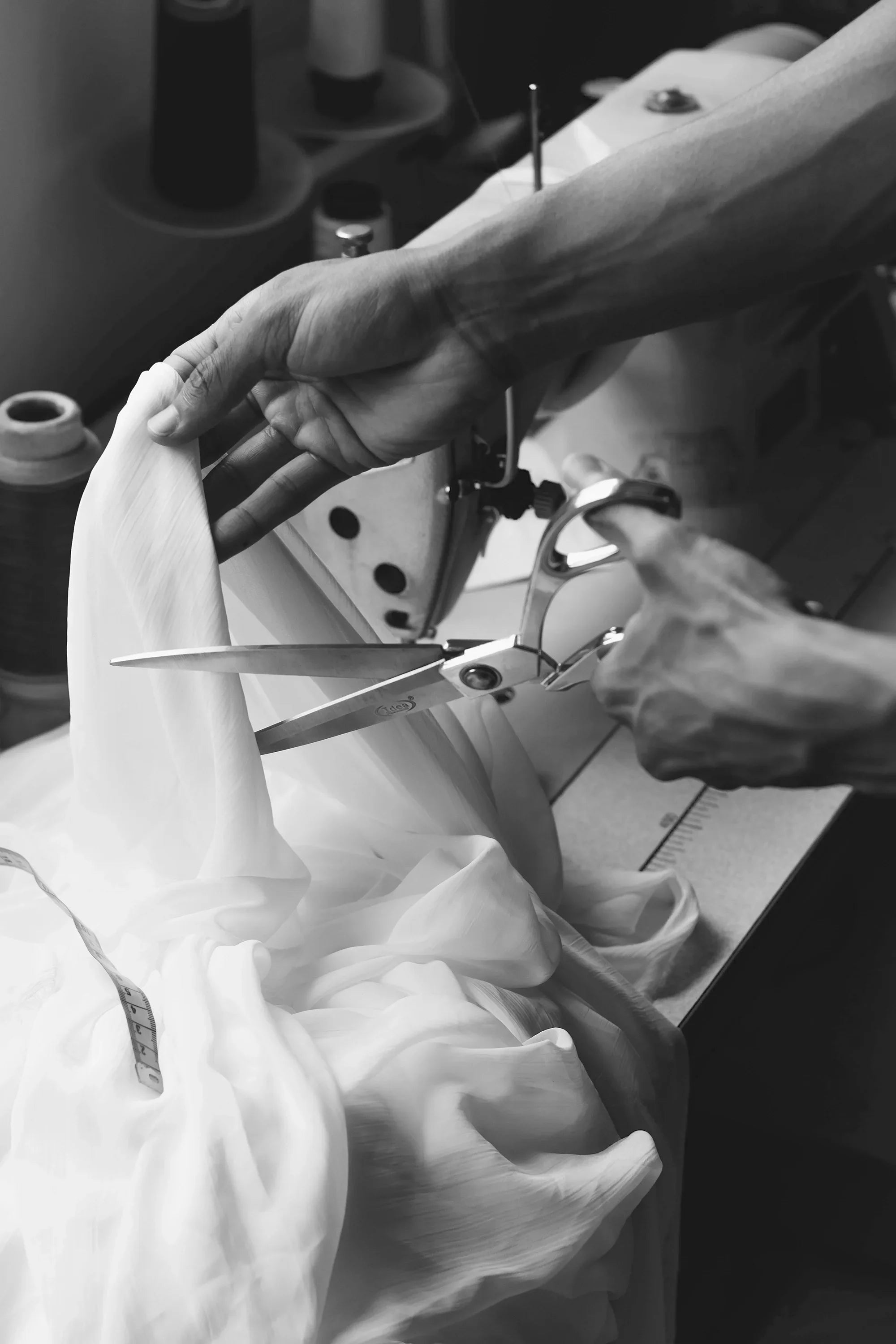 Tailor cutting fabric for maternity wear with scissors and sewing tools
