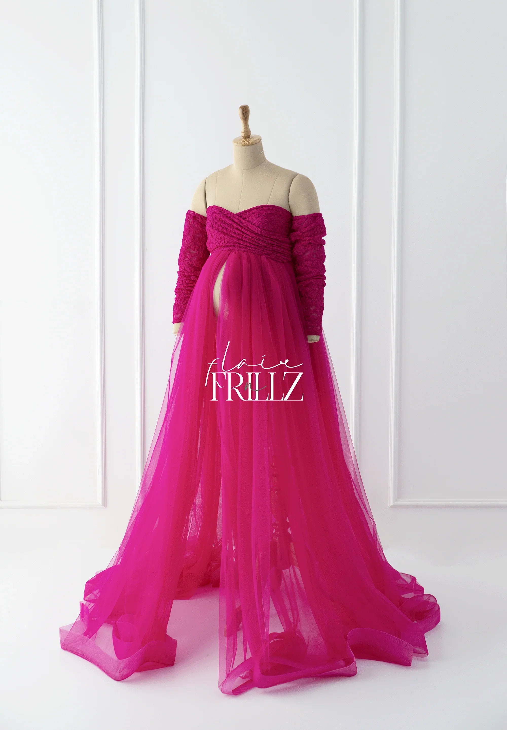 Magenta off-shoulder maternity gown with sheer tulle skirt on mannequin, elegant style