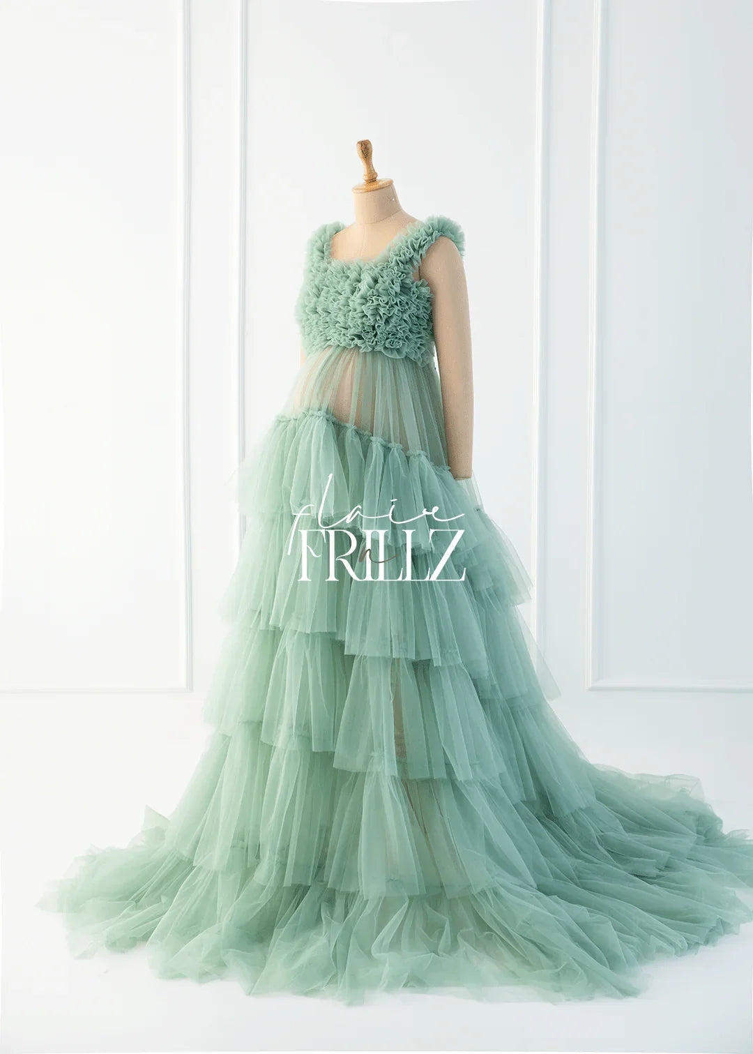 Mint green tiered maternity gown with ruffled bodice displayed on mannequin