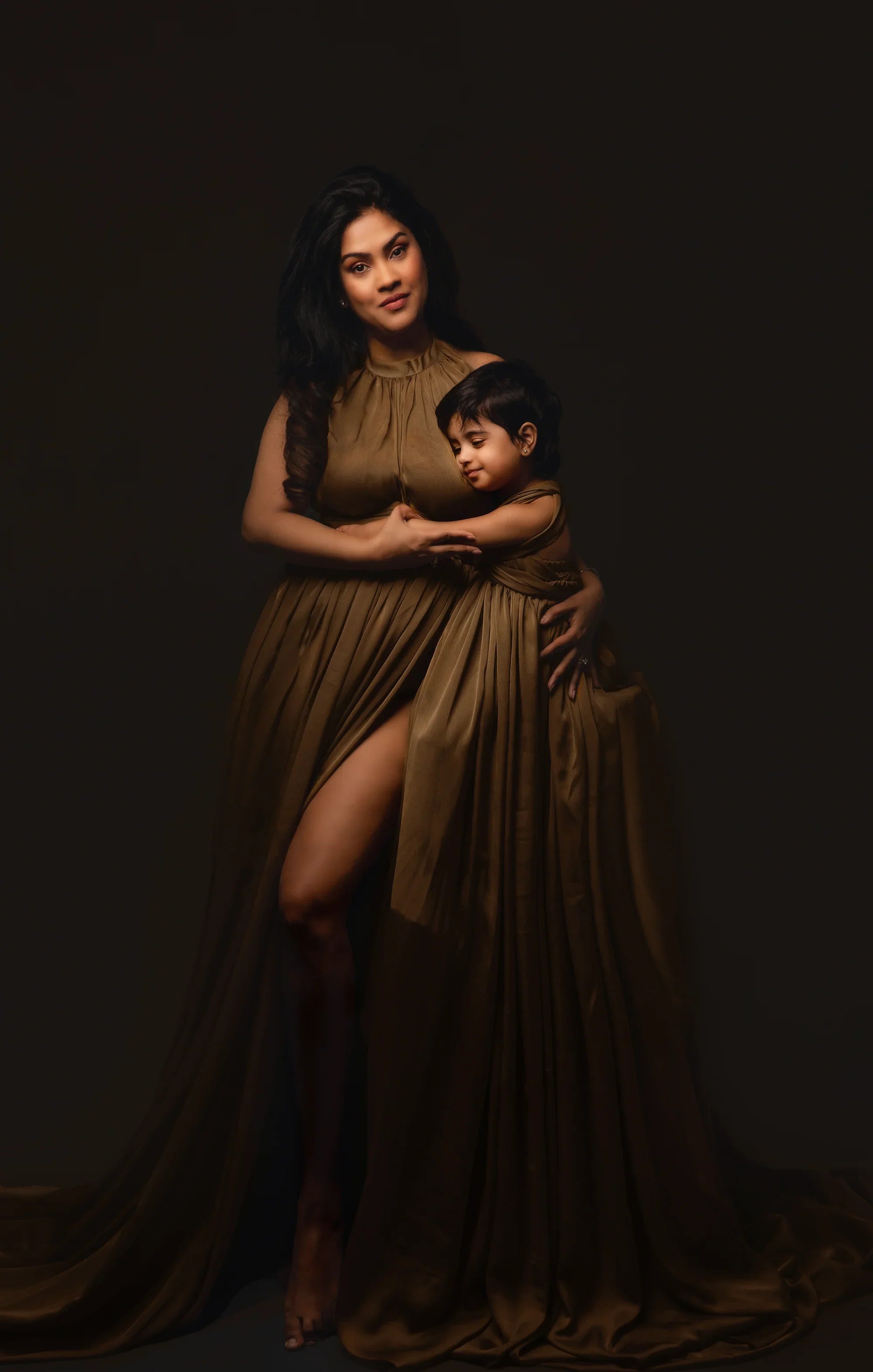 Mother and child in matching brown gowns, elegant maternity photoshoot style