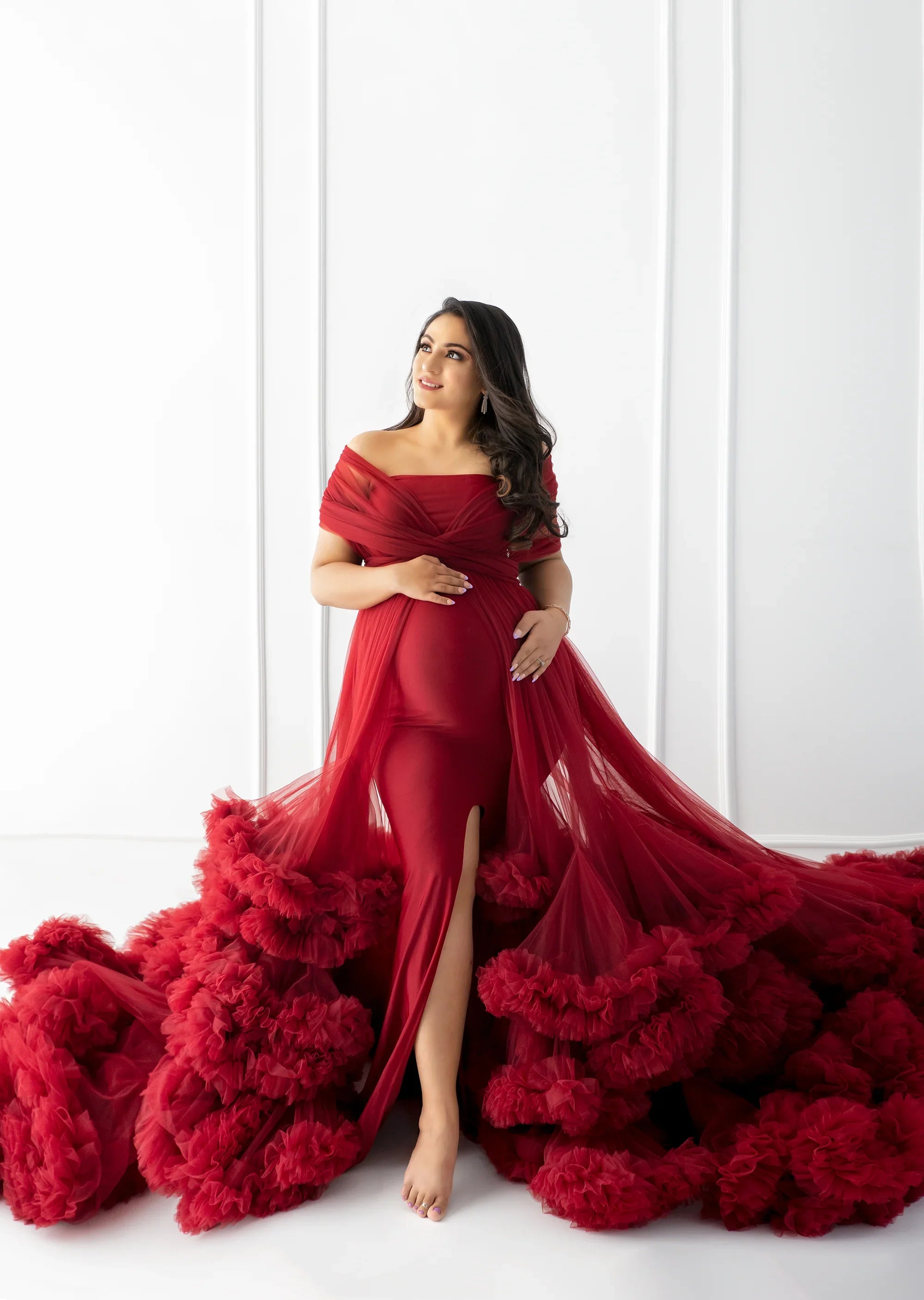 Elegant maternity gown in deep red tulle with off-shoulder design and ruffled train