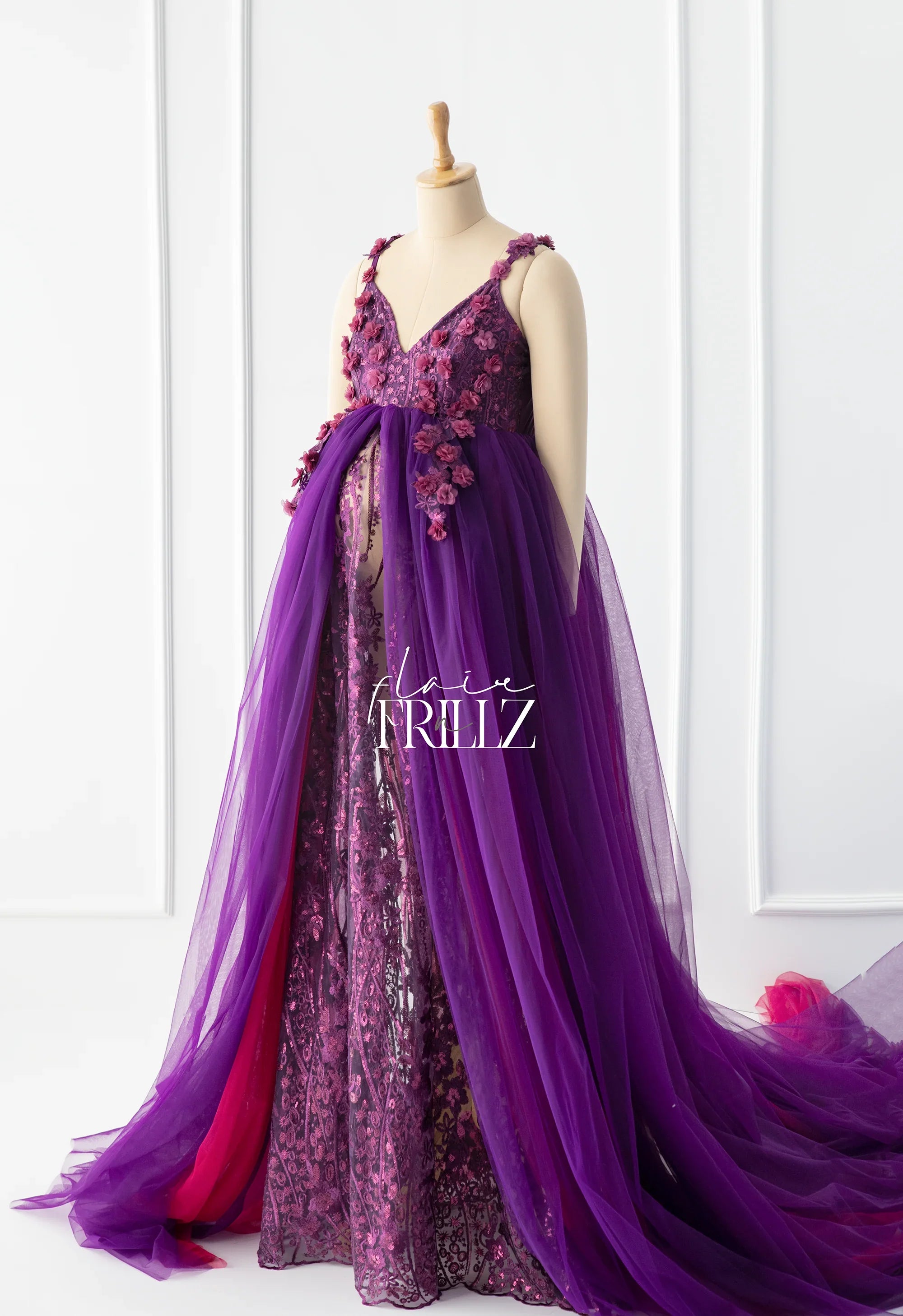 Purple floral maternity gown with sheer tulle overlay and lace details on mannequin