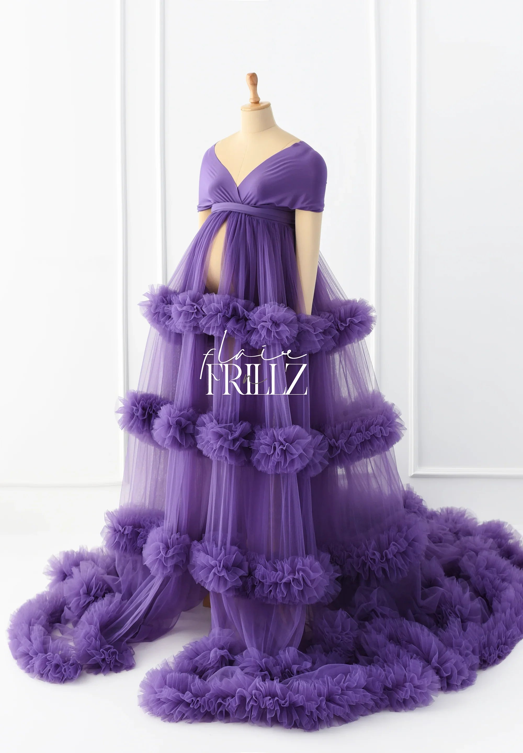 Purple maternity gown with ruffled tulle layers and open belly design on mannequin