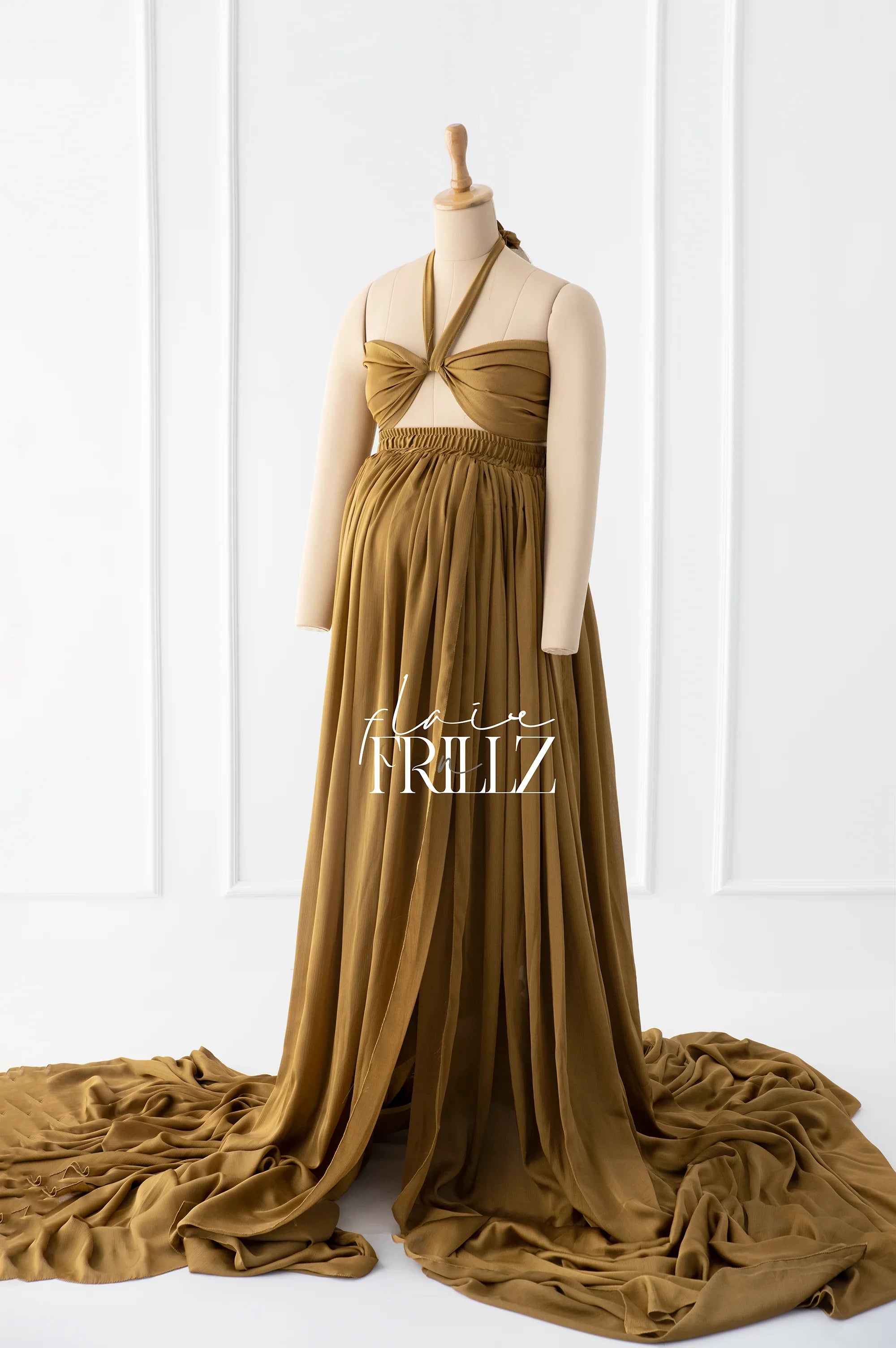 Mustard yellow maternity gown with halter neckline and flowing skirt on display mannequin