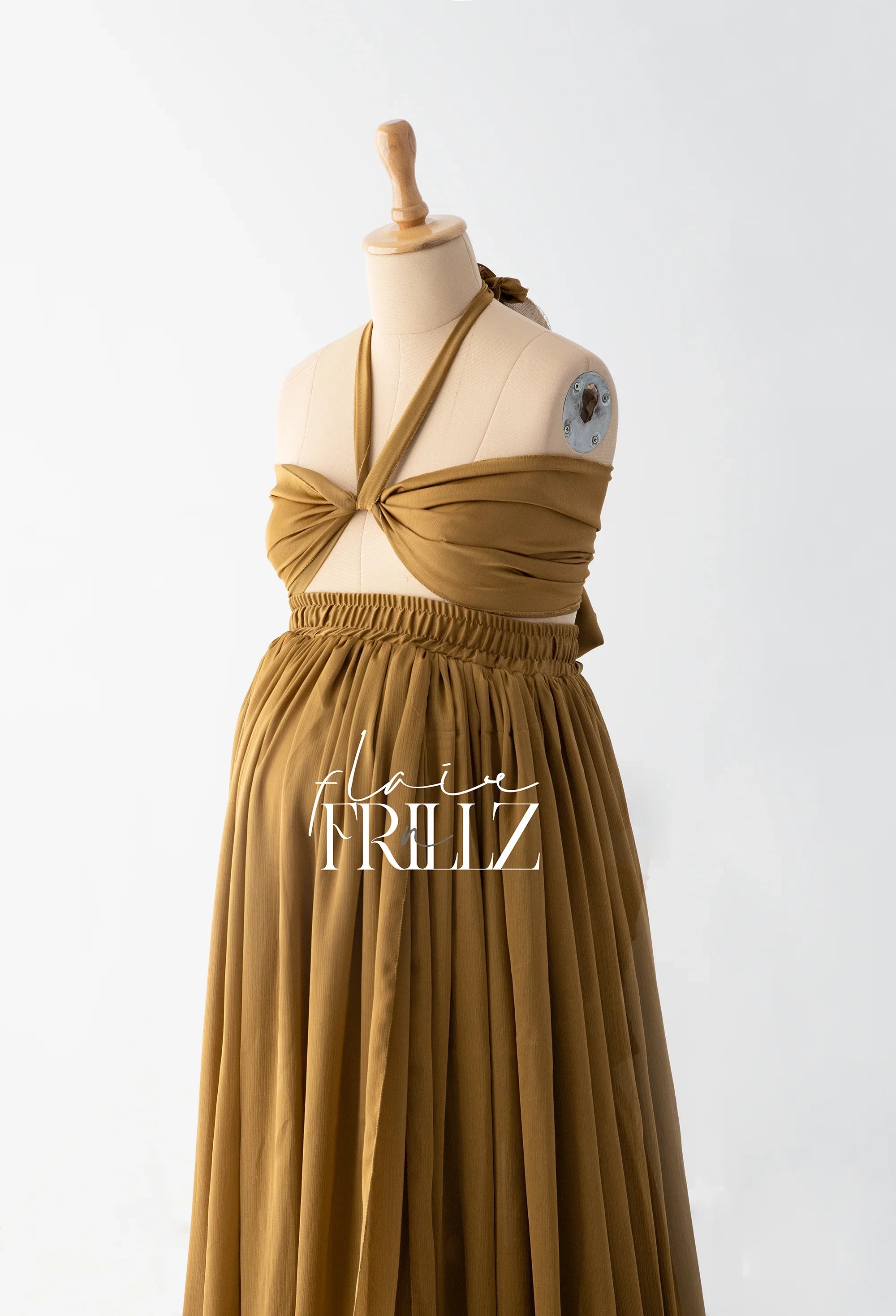 Brown pleated maternity gown with halter neck on dress form, ideal for pregnancy photoshoot