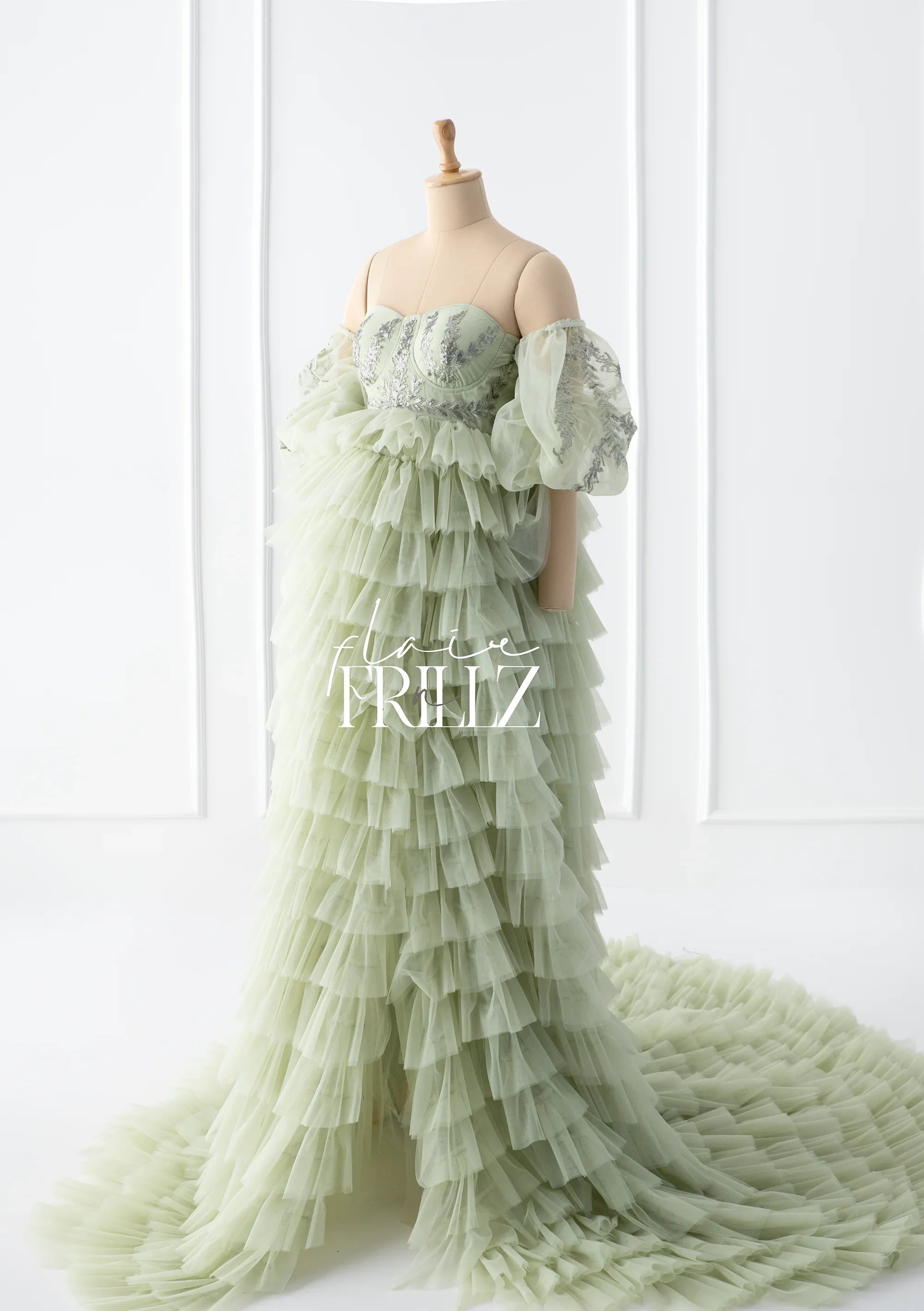 Mint green maternity gown with tiered ruffles, off-shoulder sleeves, and embroidered bodice