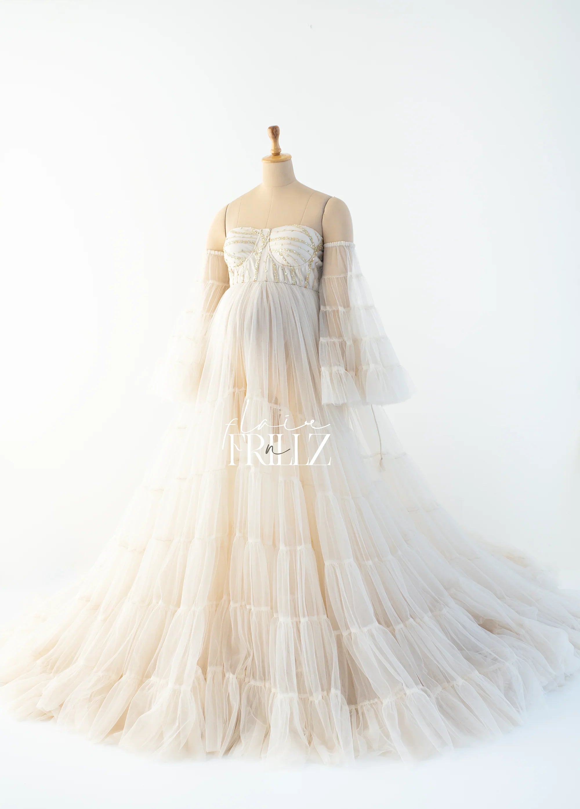 Ivory off-shoulder maternity gown with layered tulle and fitted bodice on mannequin