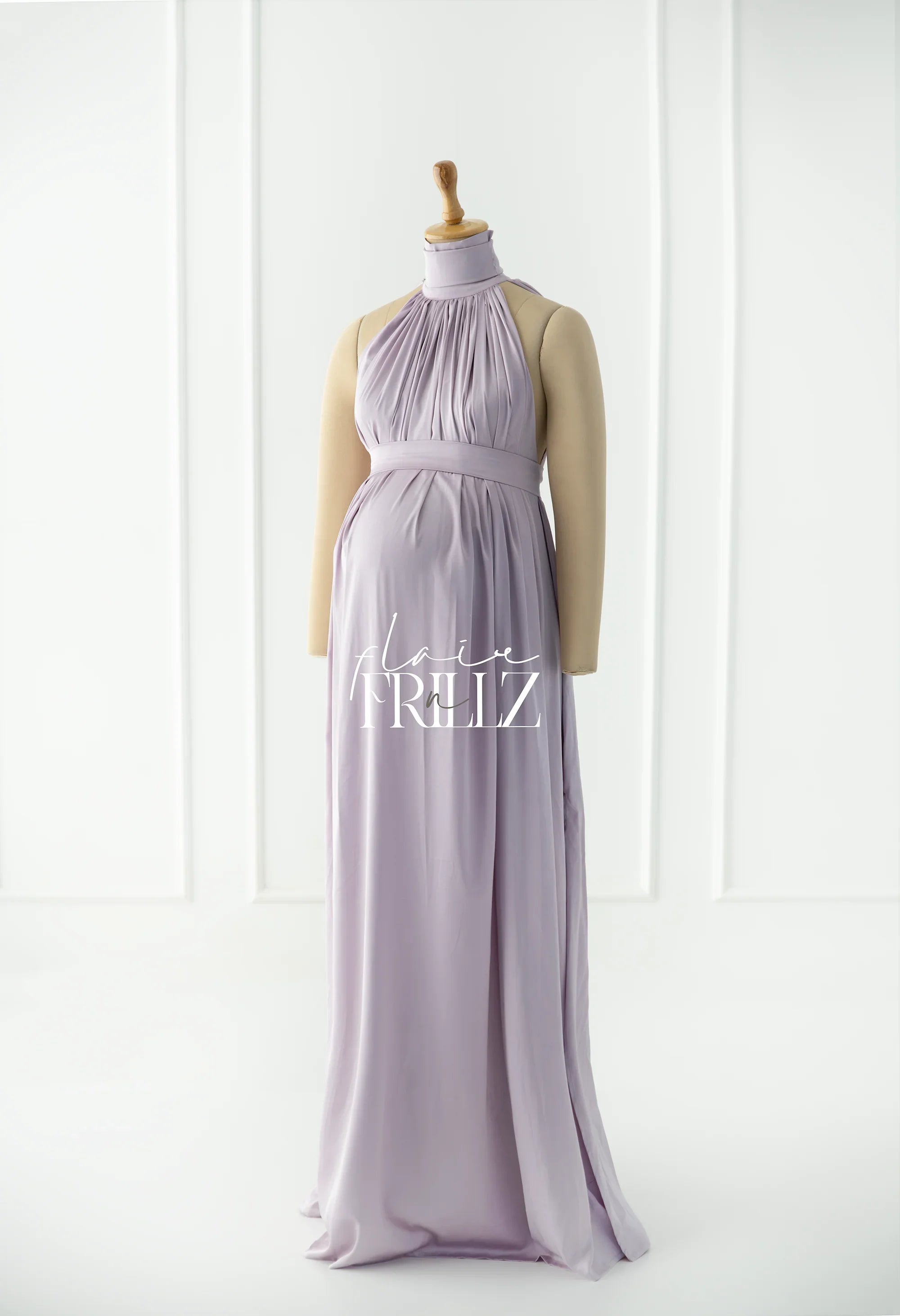 Lilac maternity gown with halter neckline and flowing skirt on mannequin in studio setting