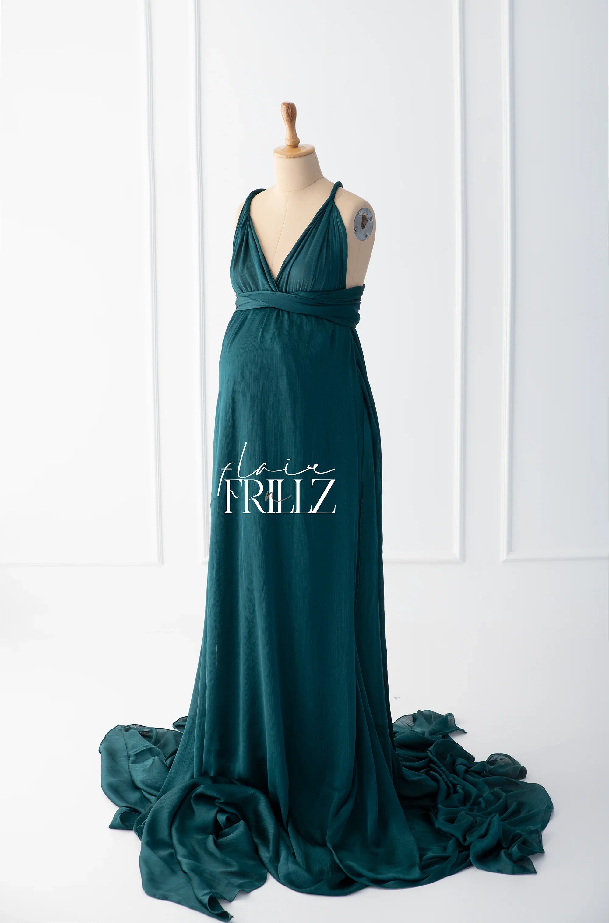 Teal maternity gown with V-neck and flowing train displayed on a dress form