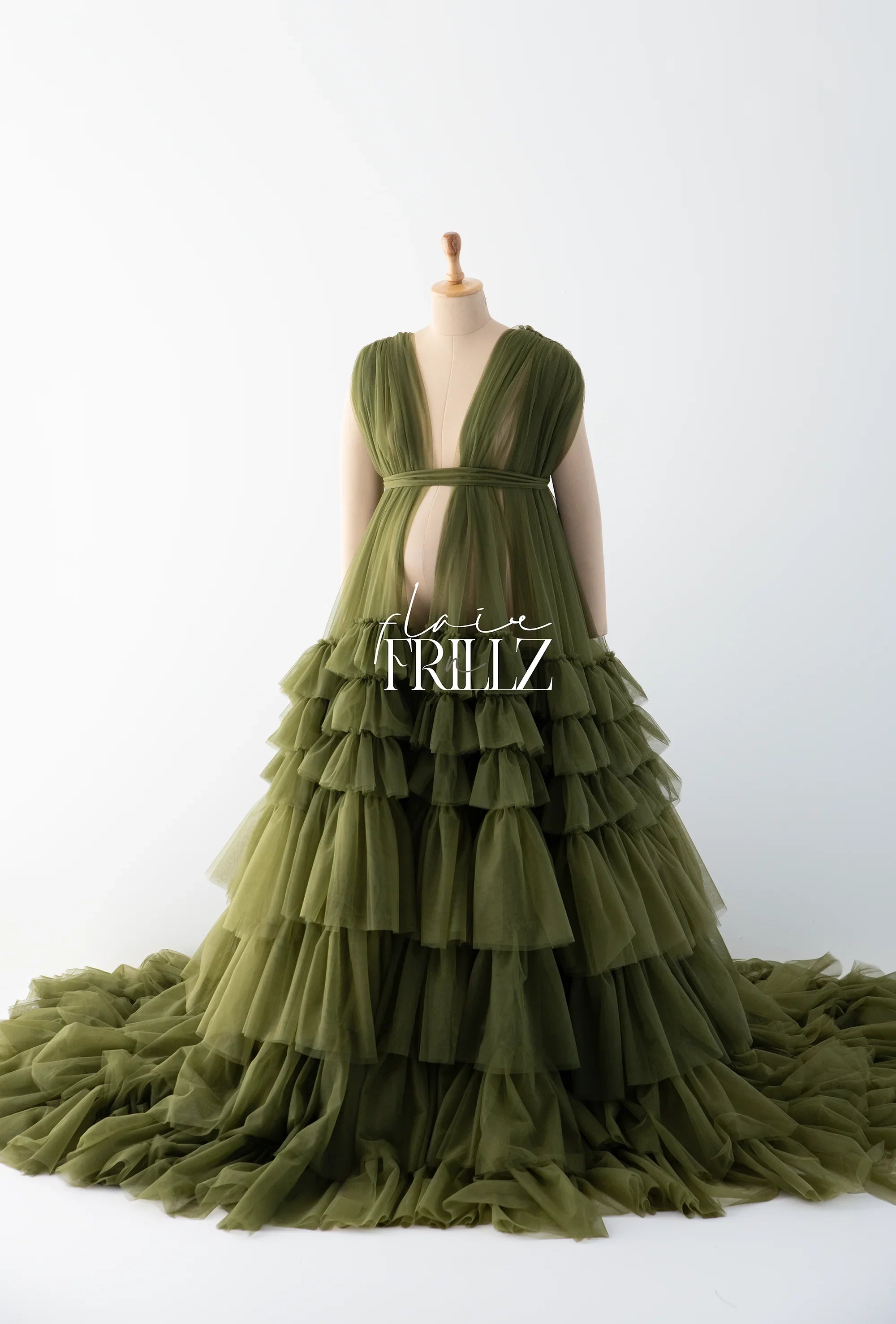 Olive green ruffled tulle maternity gown with deep V-neck and layered skirt on mannequin