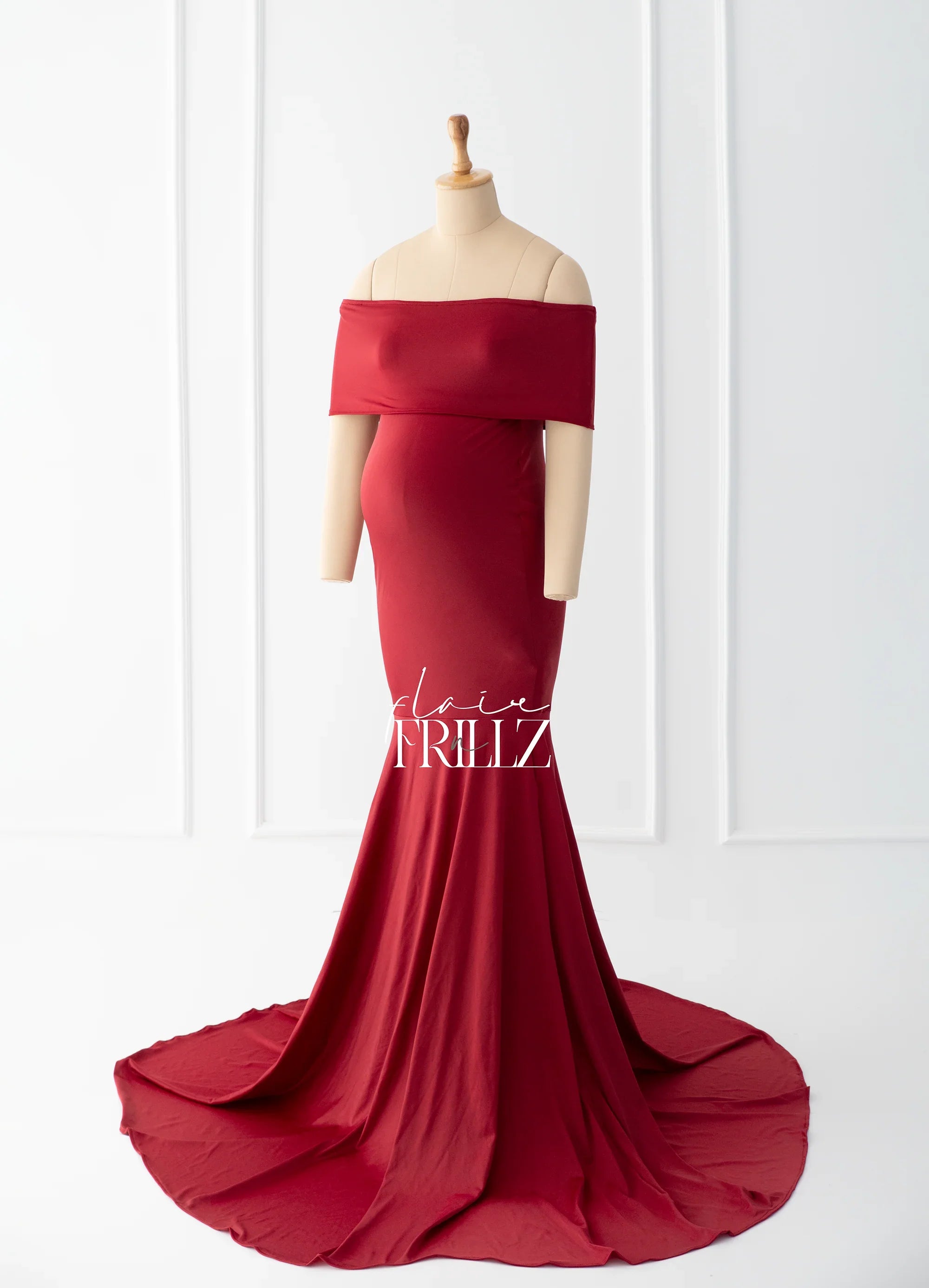 Red off-shoulder maternity gown with mermaid train displayed on mannequin