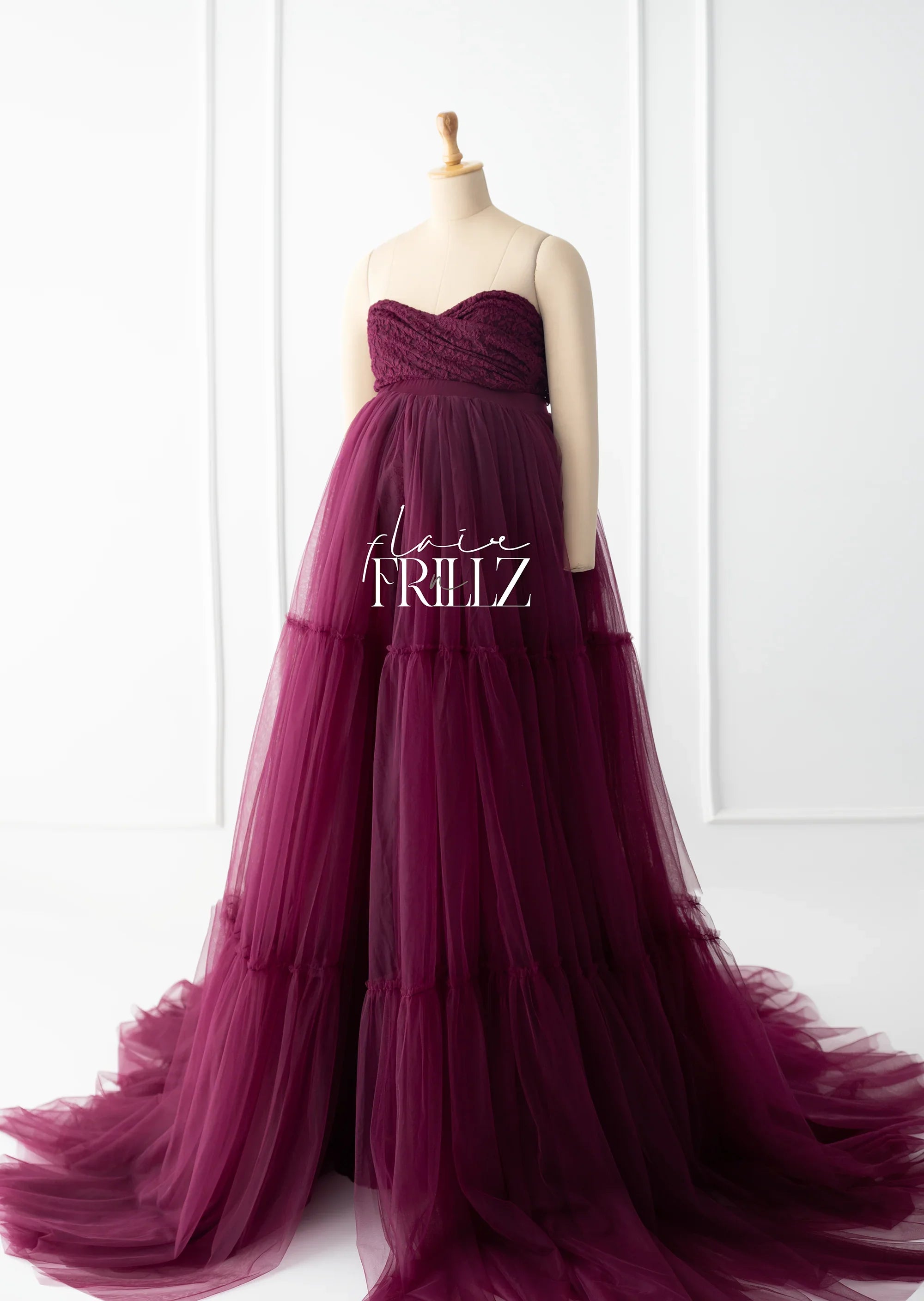Burgundy strapless maternity gown with layered tulle skirt displayed on mannequin
