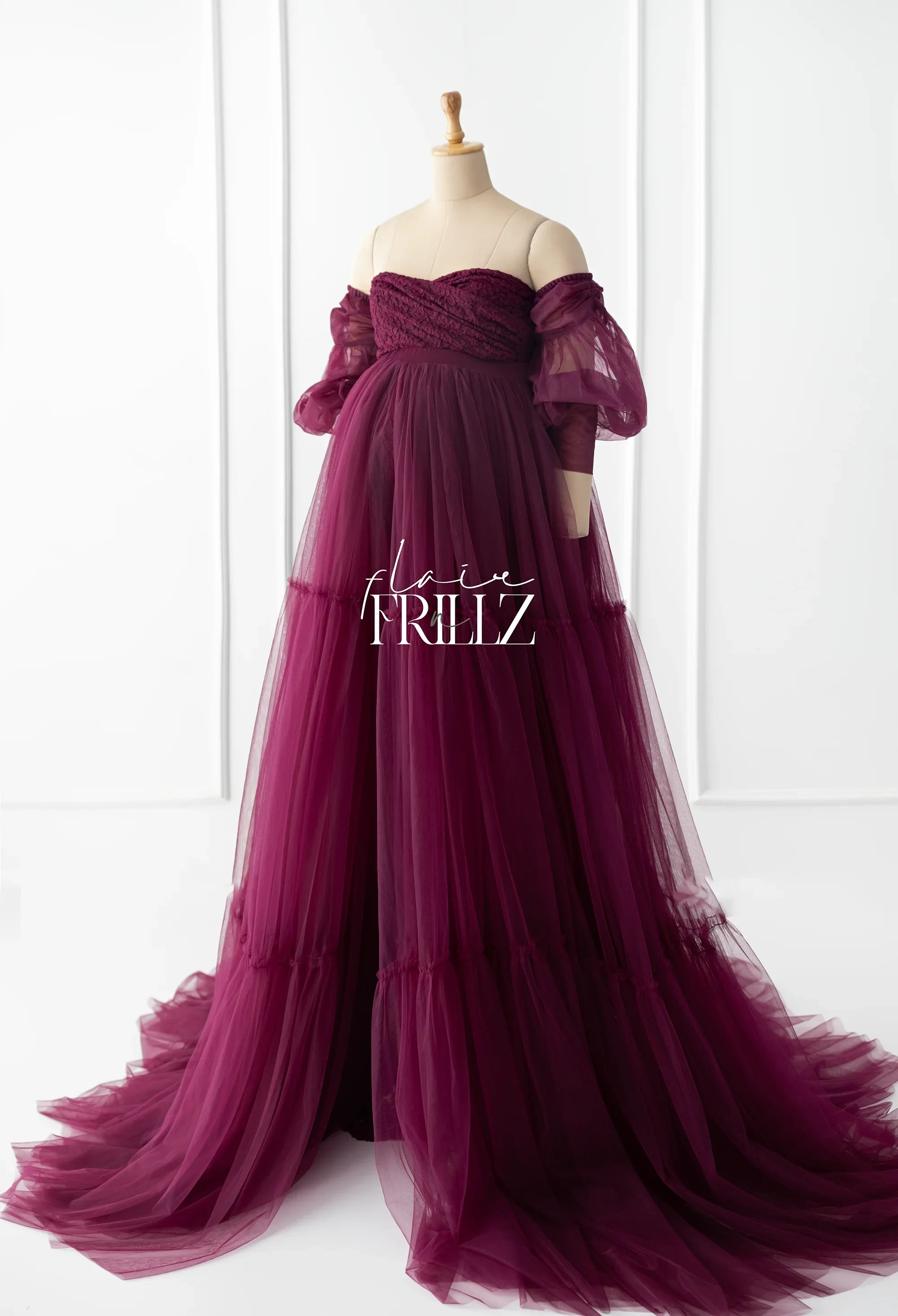 Burgundy tulle maternity gown with off-shoulder sheer puff sleeves on mannequin